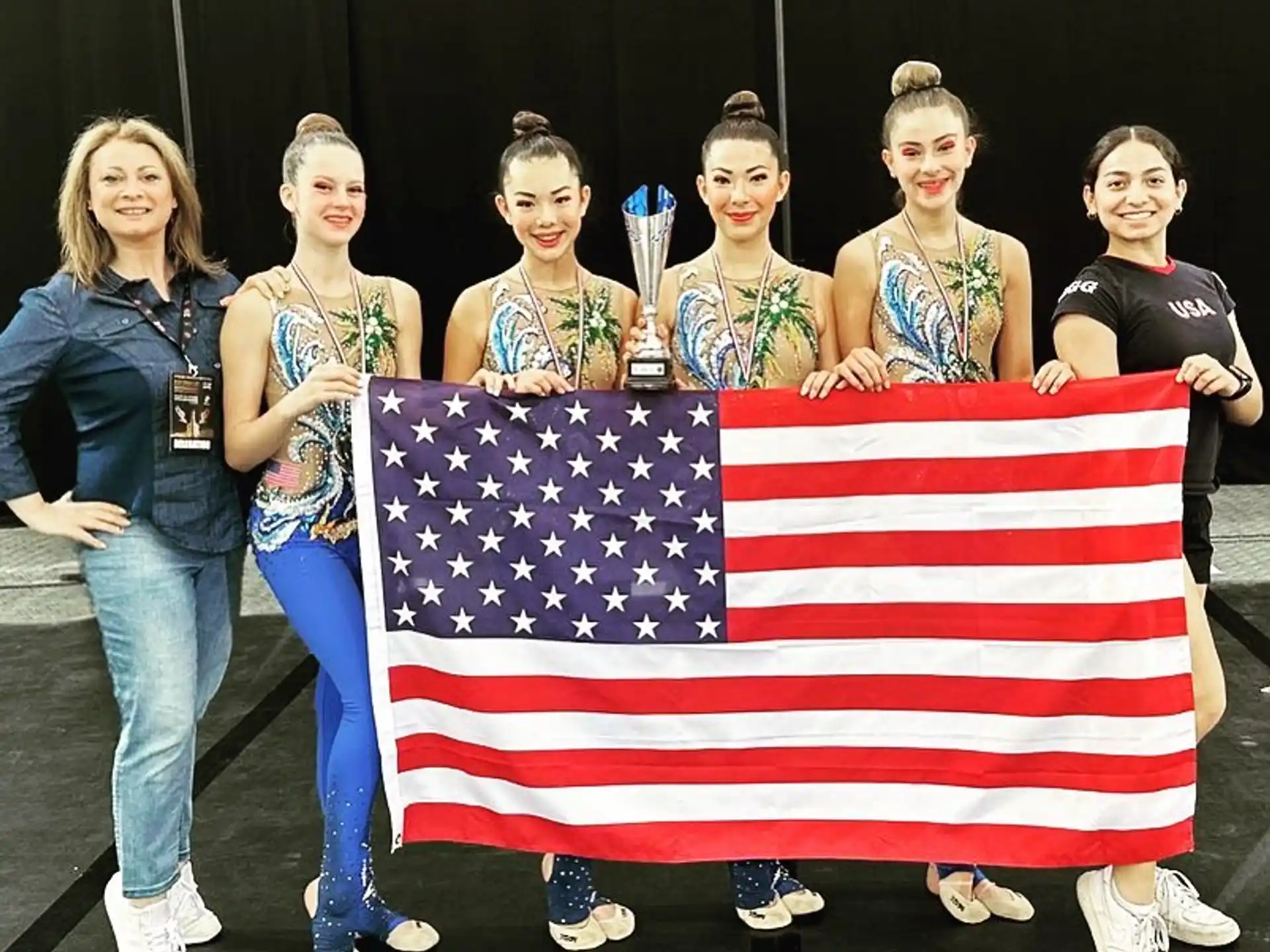 a group of women posing for a photo with a flag