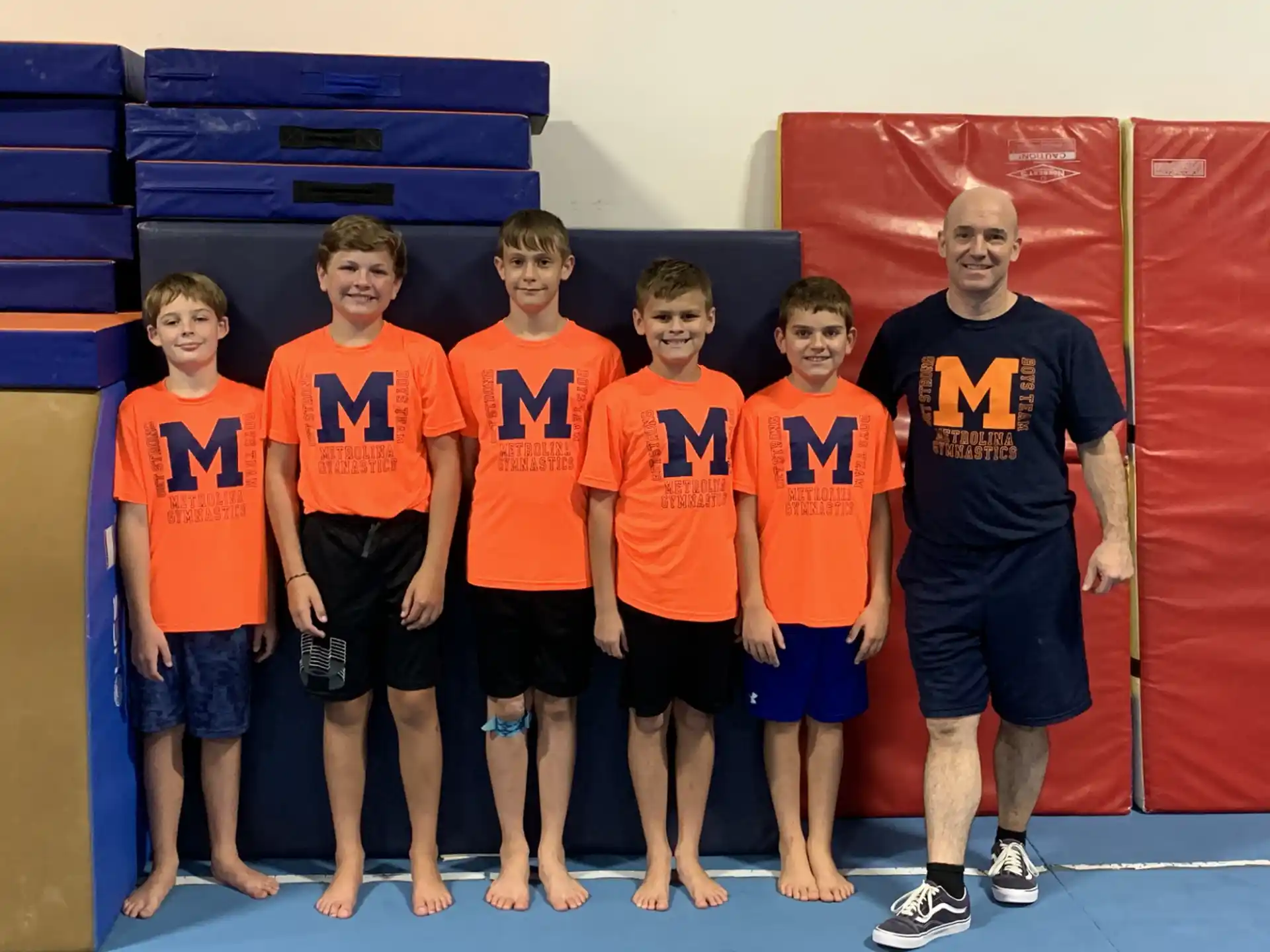 a group of boys in orange shirts