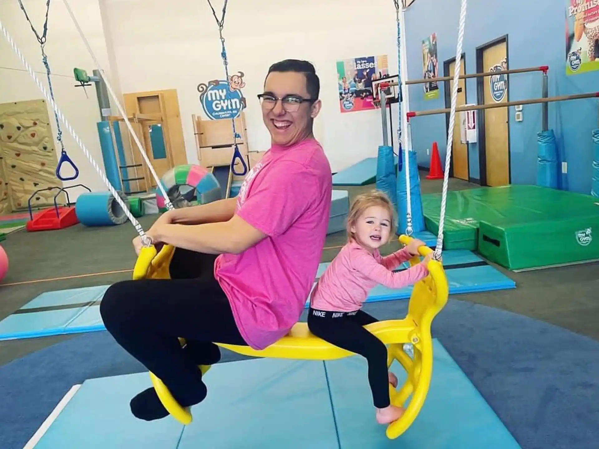 a person and a girl on a playground swing