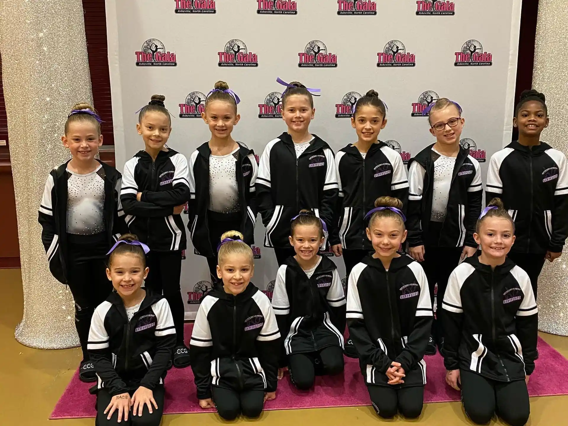 a group of people in black and white uniforms posing for a photo