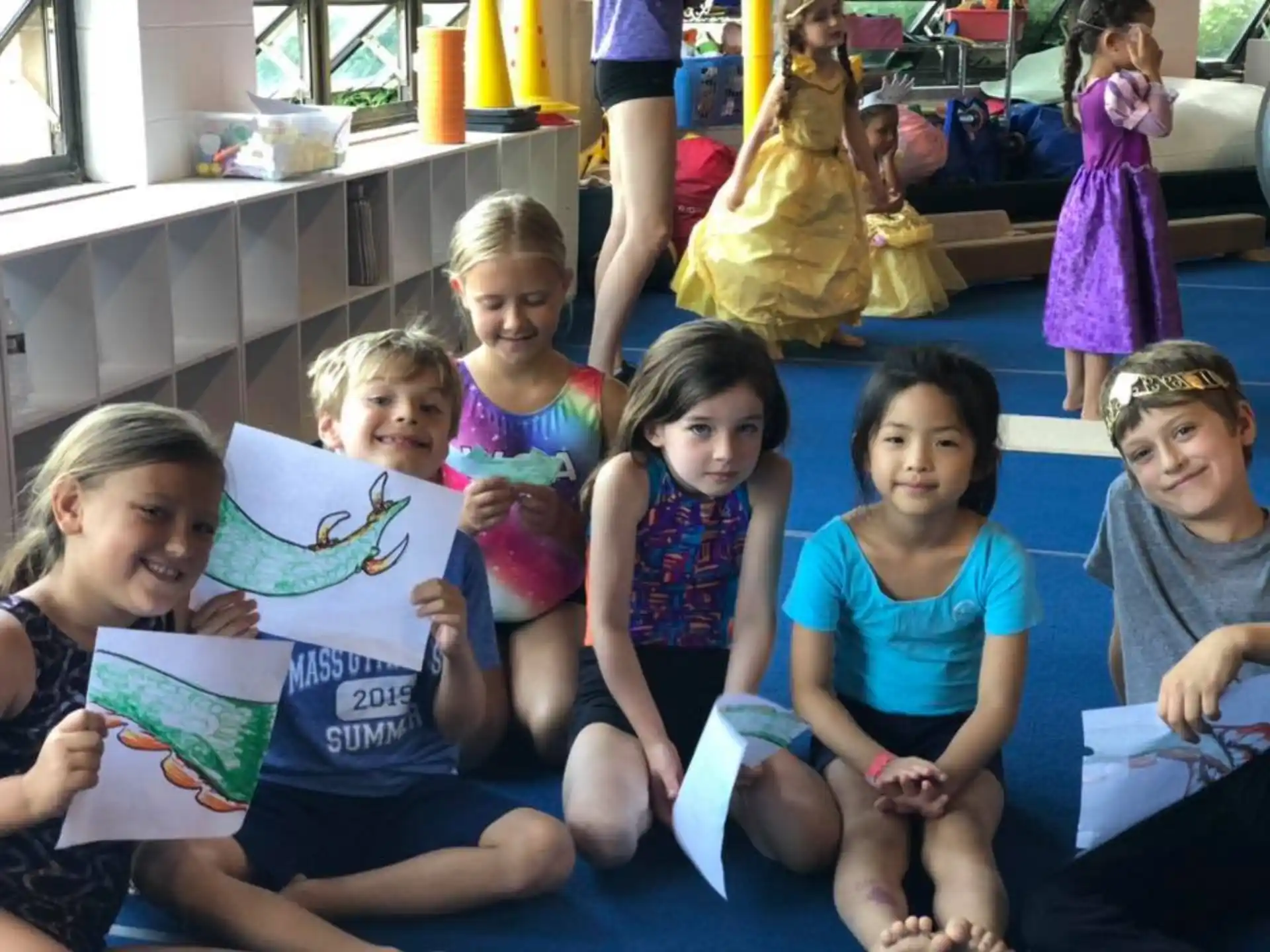a group of children sitting on the floor holding books