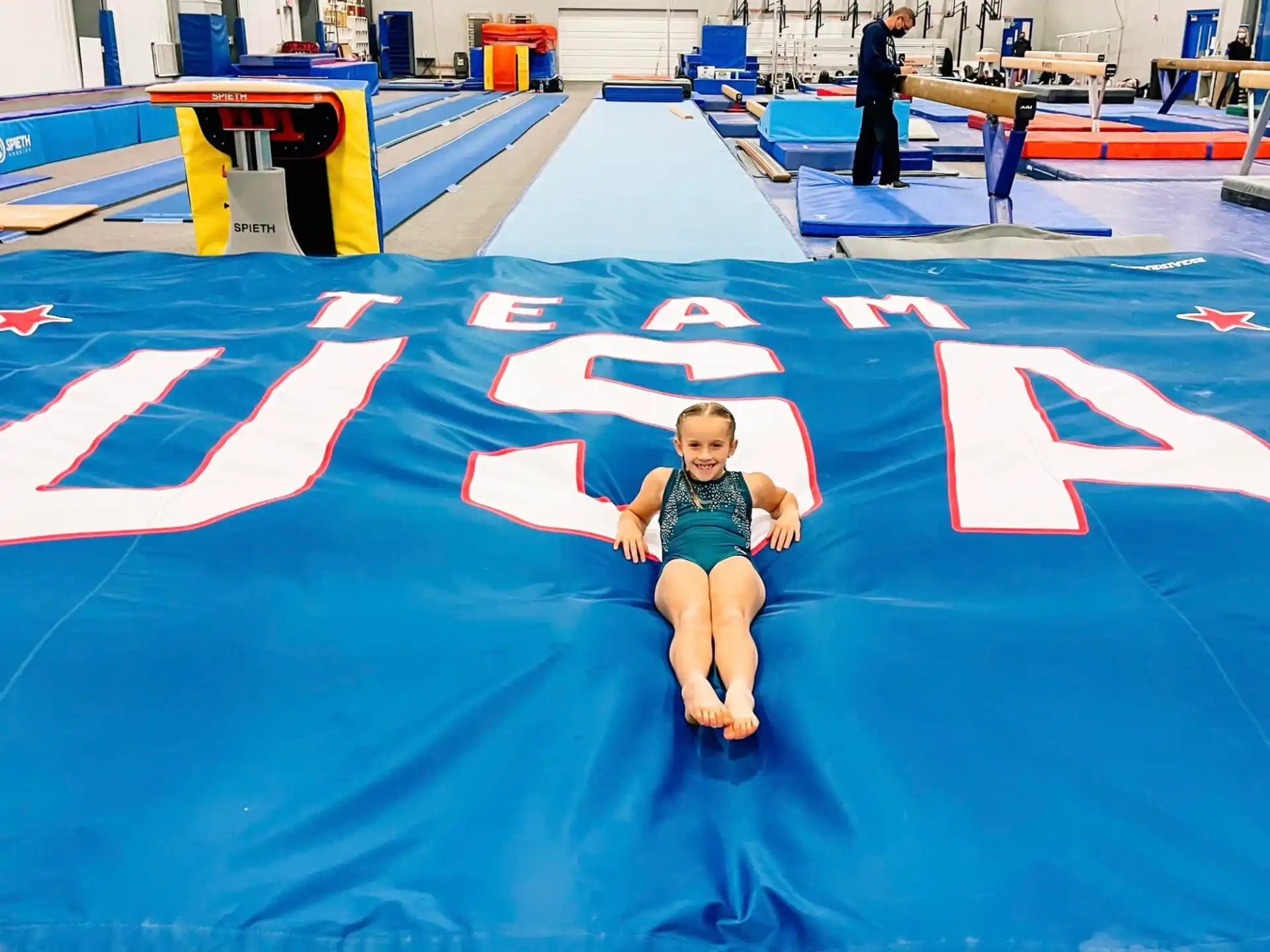 a boy sitting on a blue mat