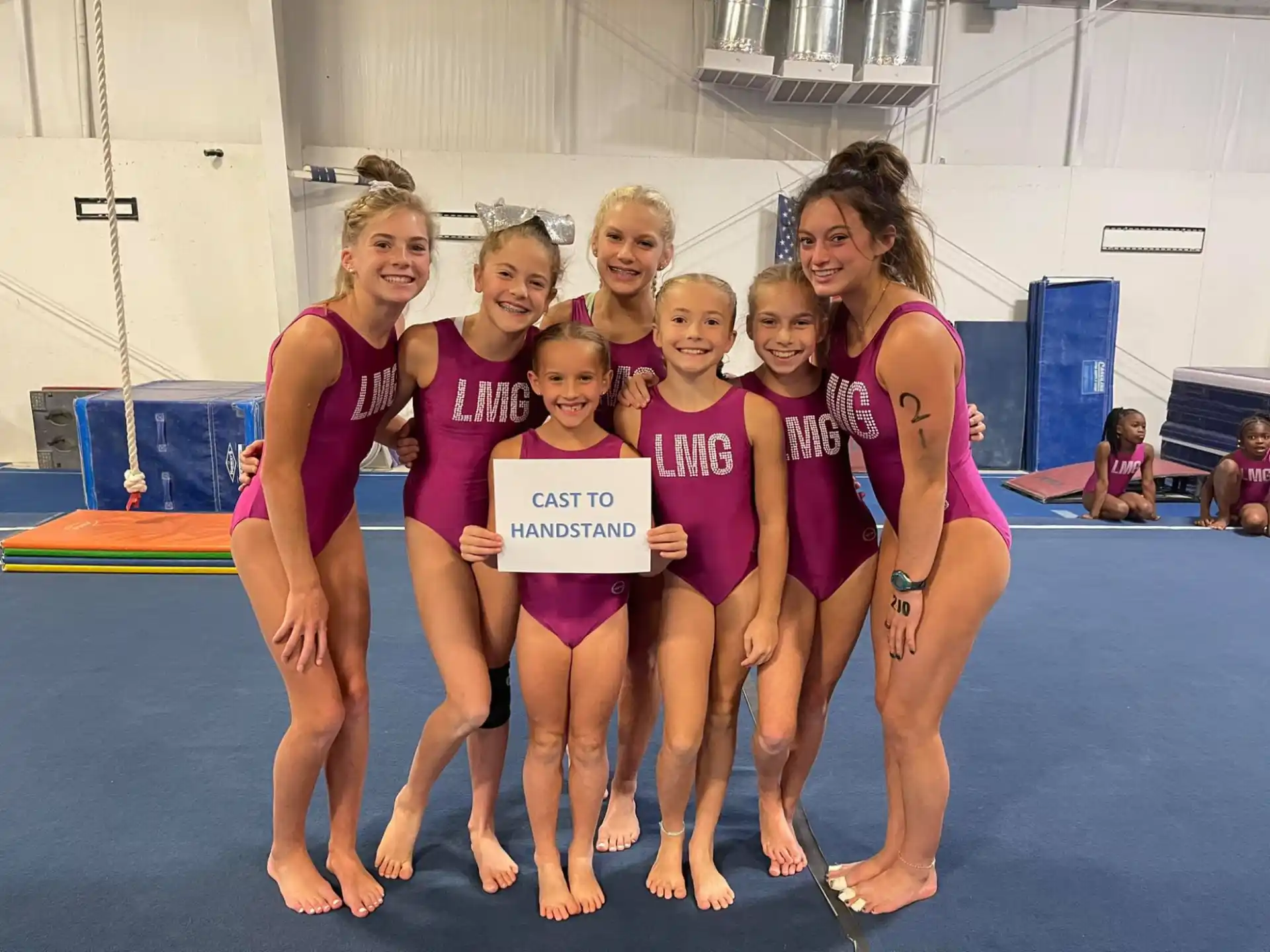 a group of women in swimsuits holding a sign