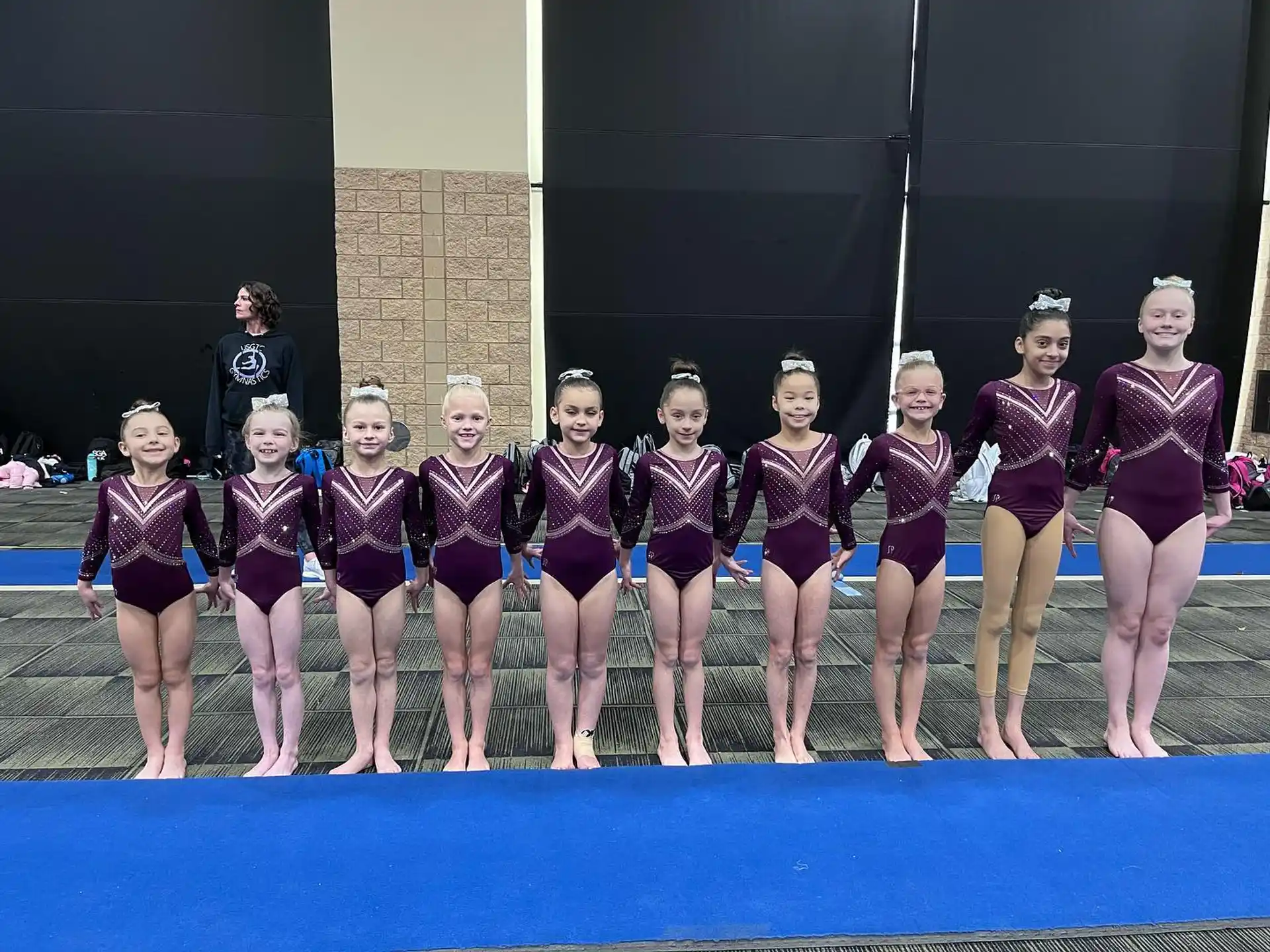a group of girls in leotards posing for a photo