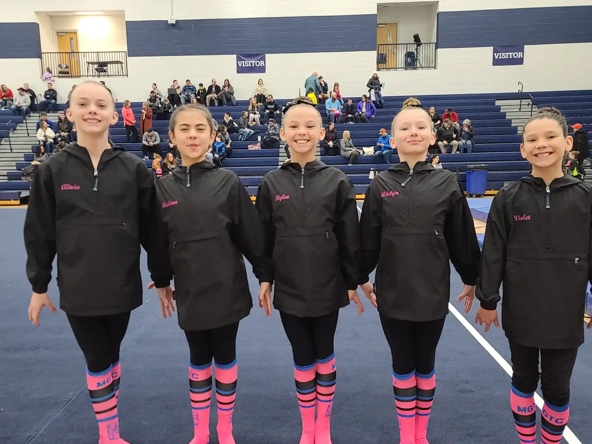 a group of girls wearing ice skates and standing on ice