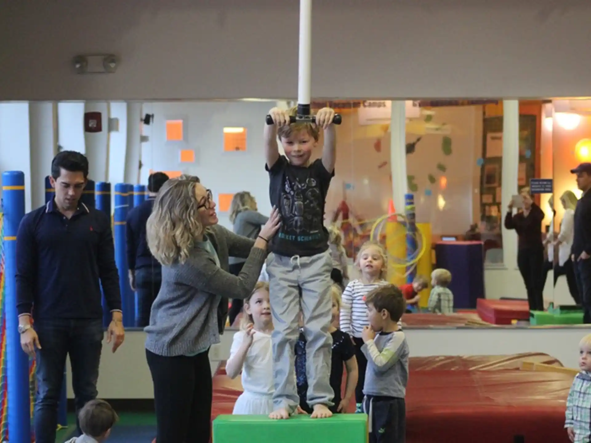 a group of people standing in a room with a person and children