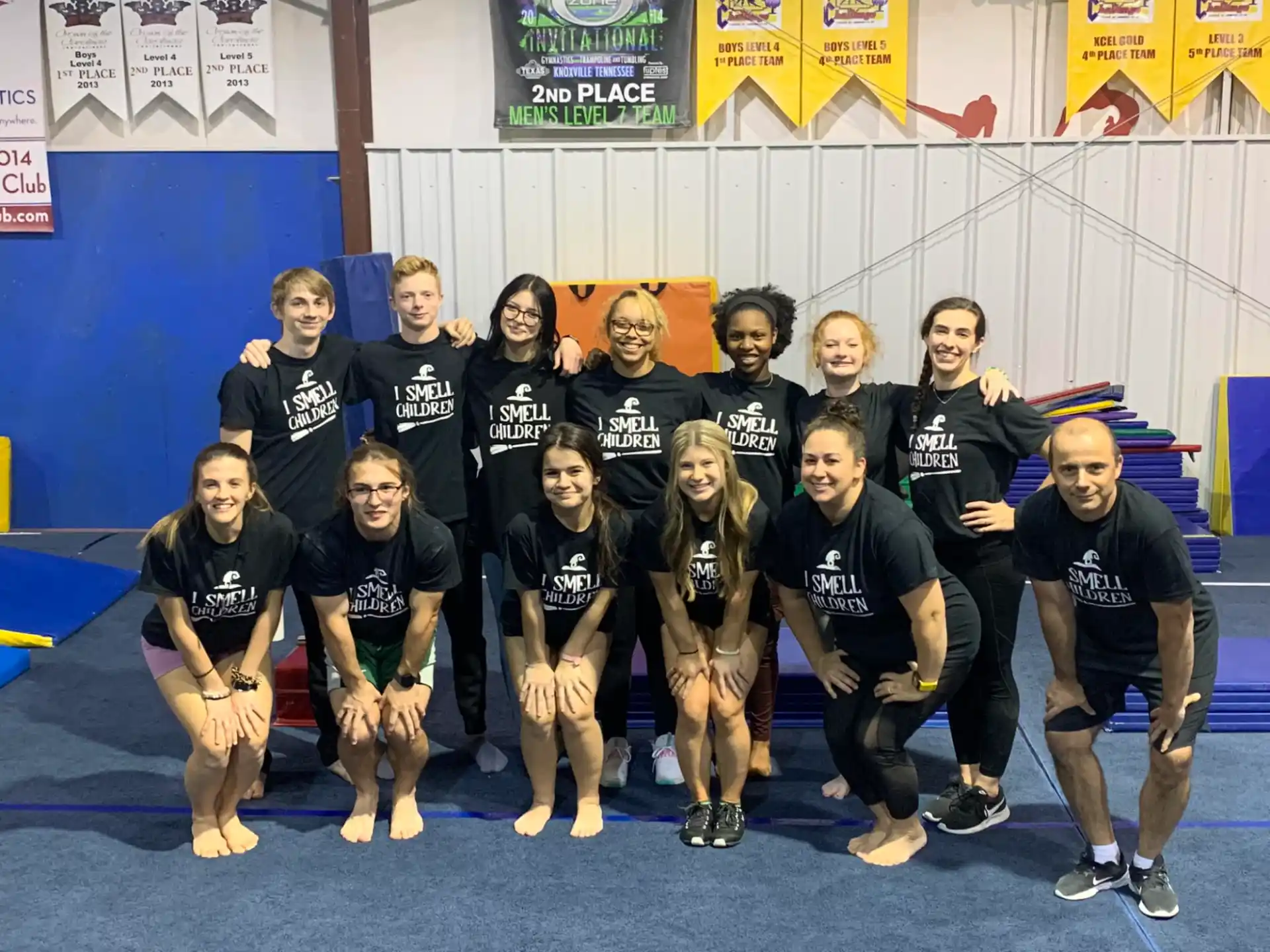 a group of people wearing matching black shirts and posing for a photo