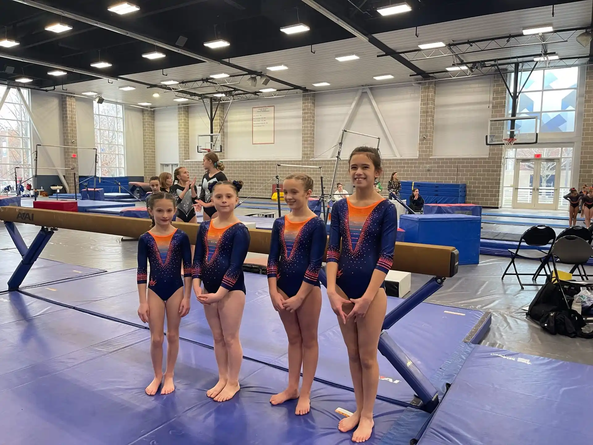 a group of girls in leotards posing for a photo