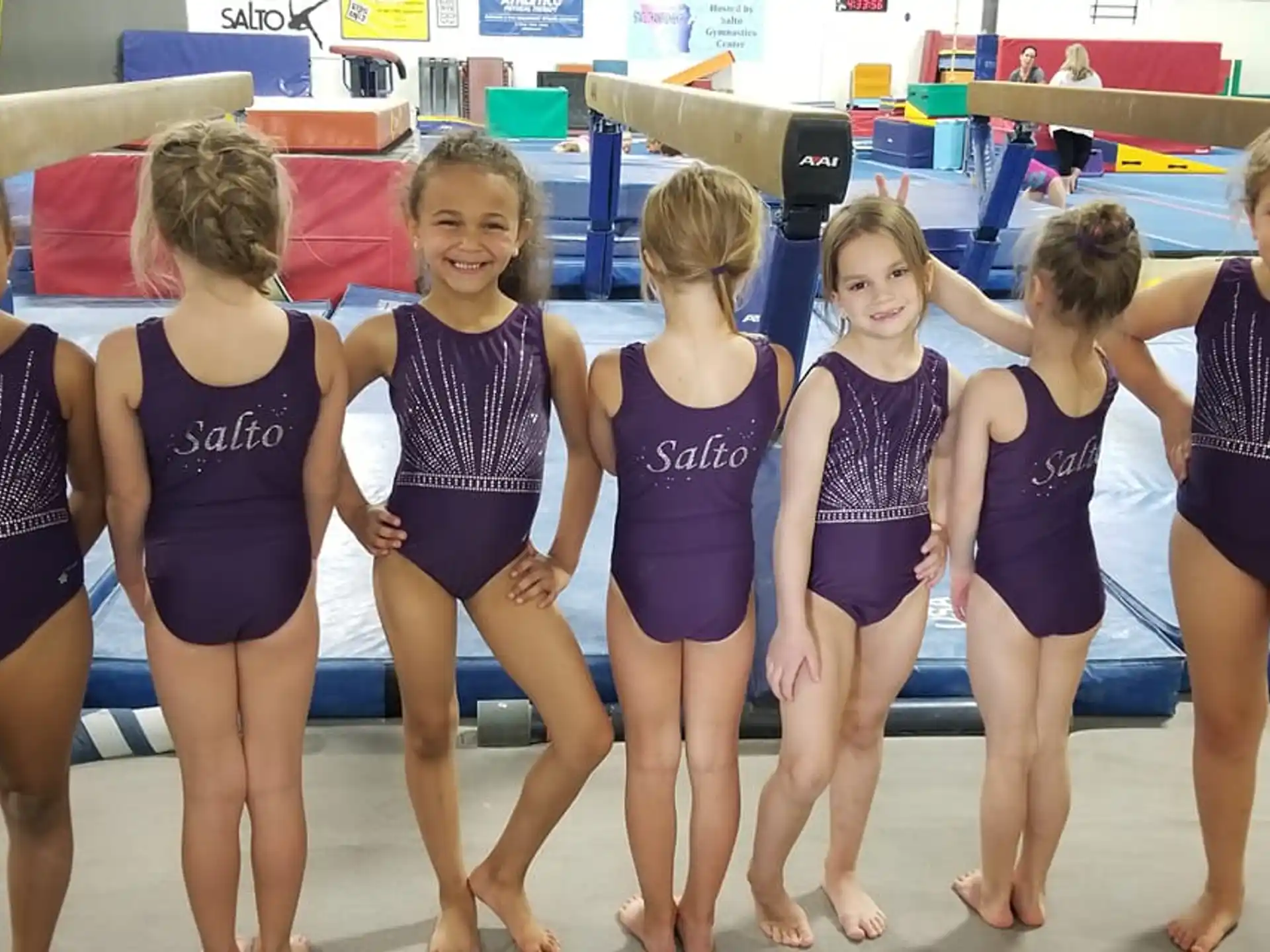 a group of girls in leotards posing for a photo