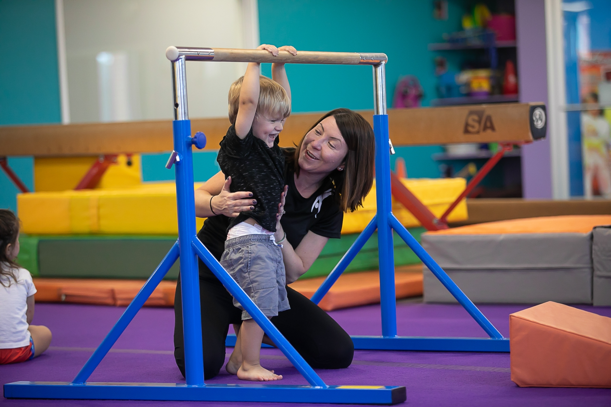 a woman holding a girl on a bar