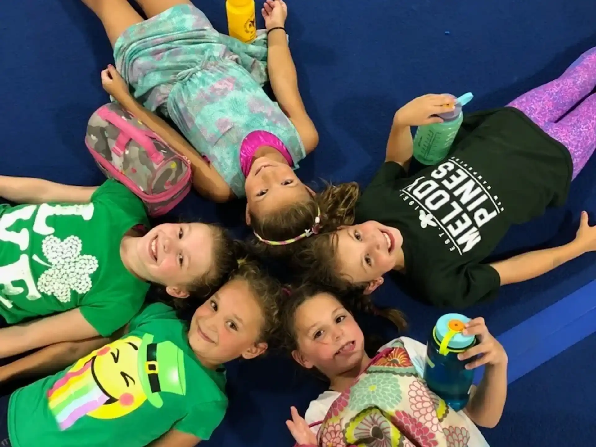 a group of children lying on the ground holding objects