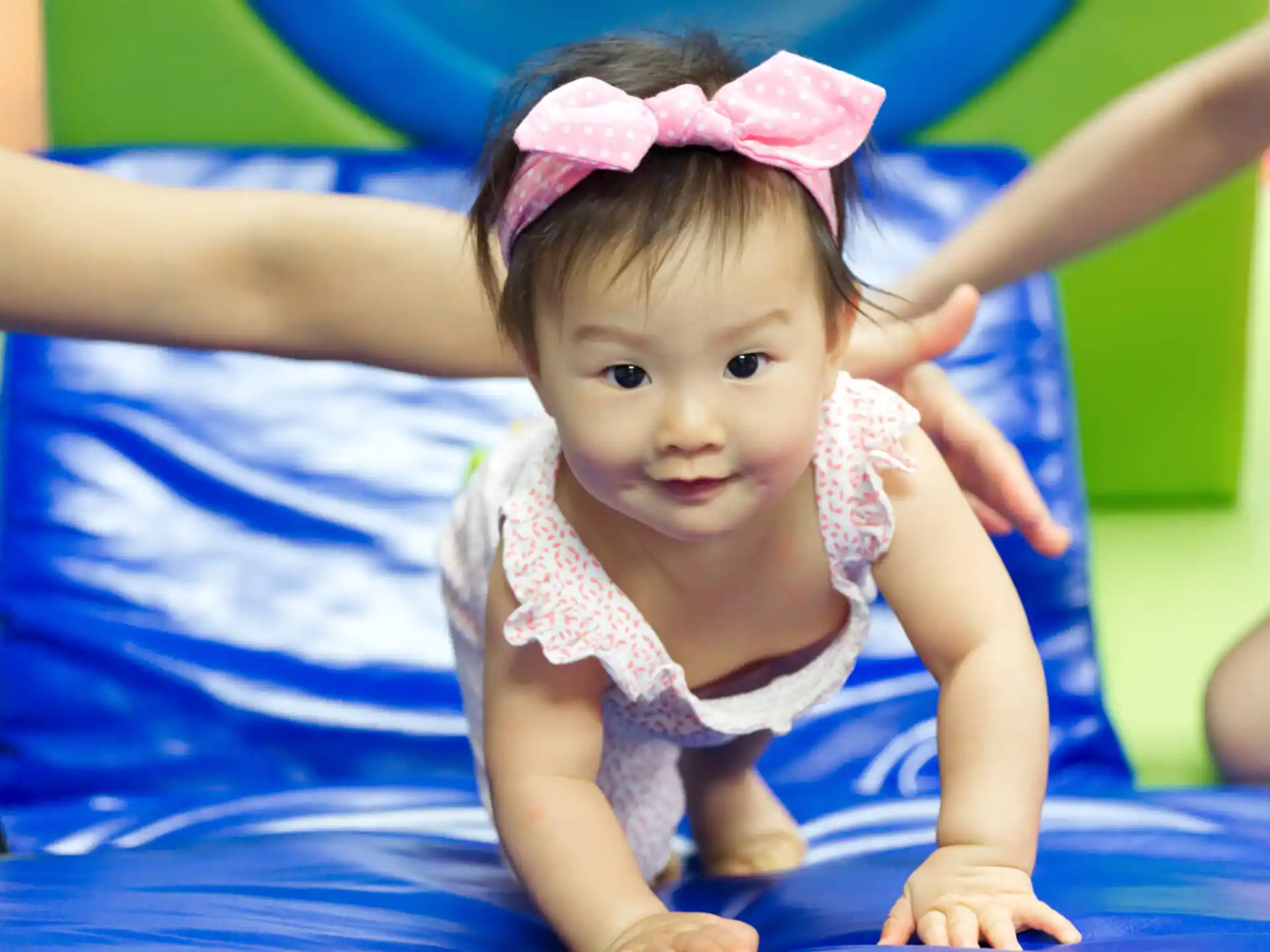 a baby girl wearing a pink bow