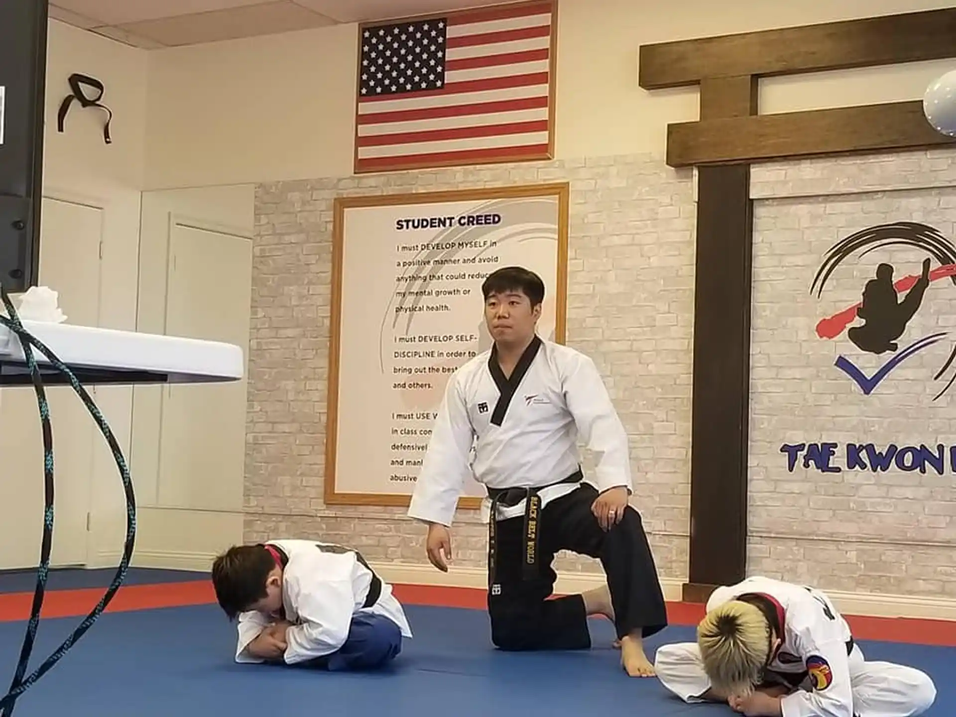 a person standing on a mat with another man lying on the ground