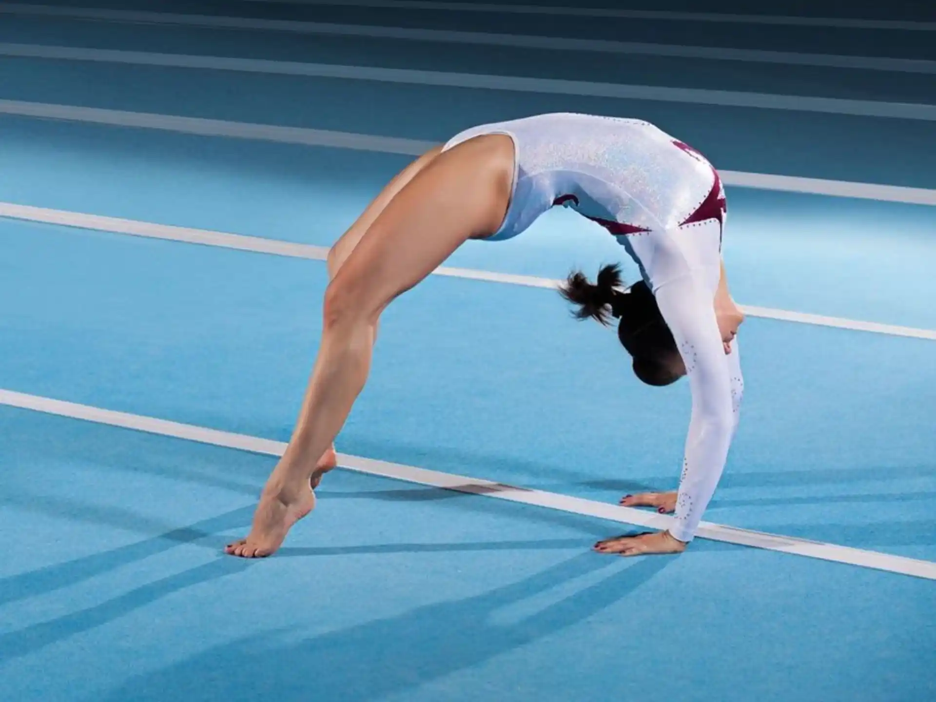 a person doing a handstand on a blue track