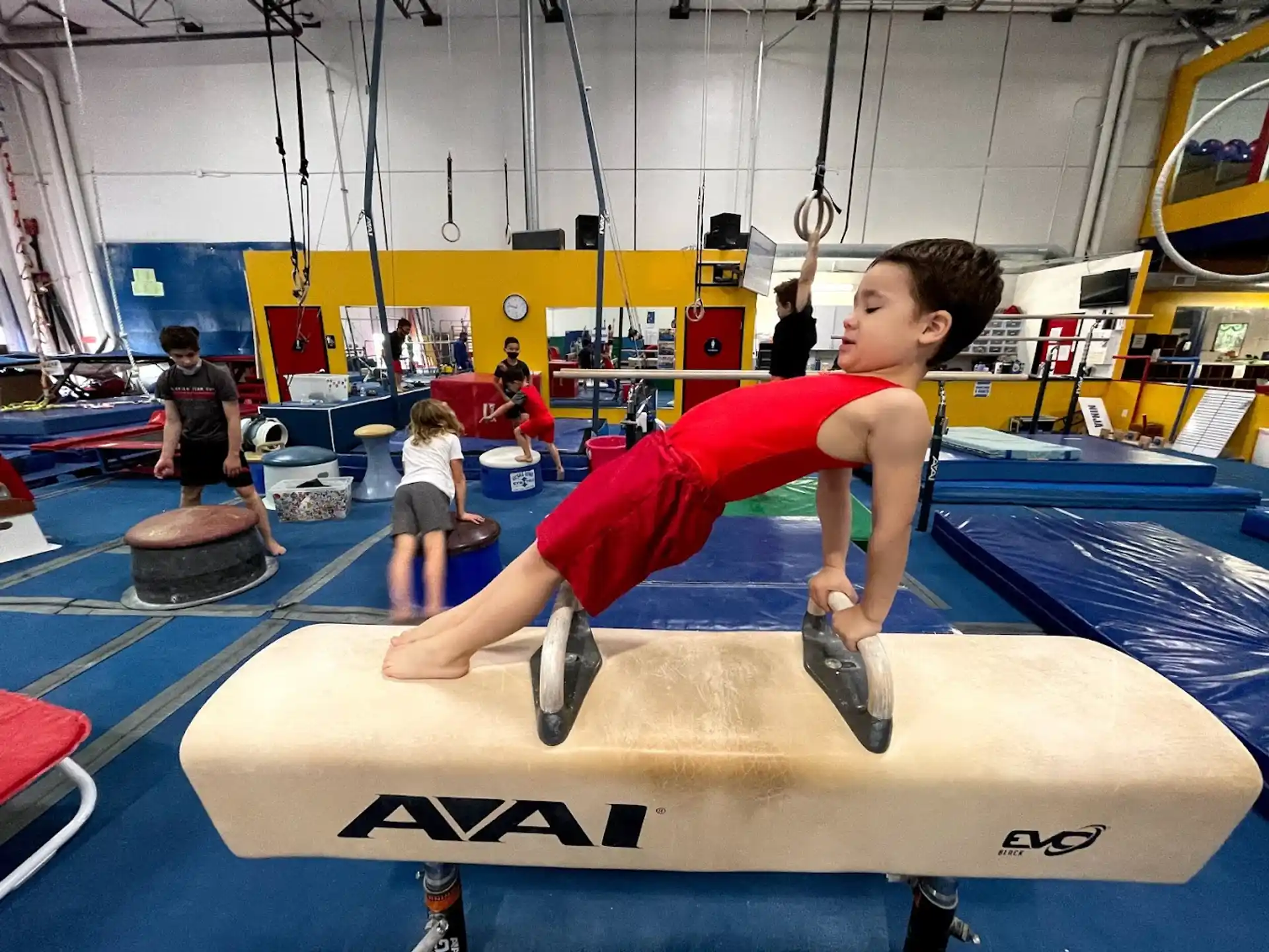 a boy doing a plank on a mat in a gym