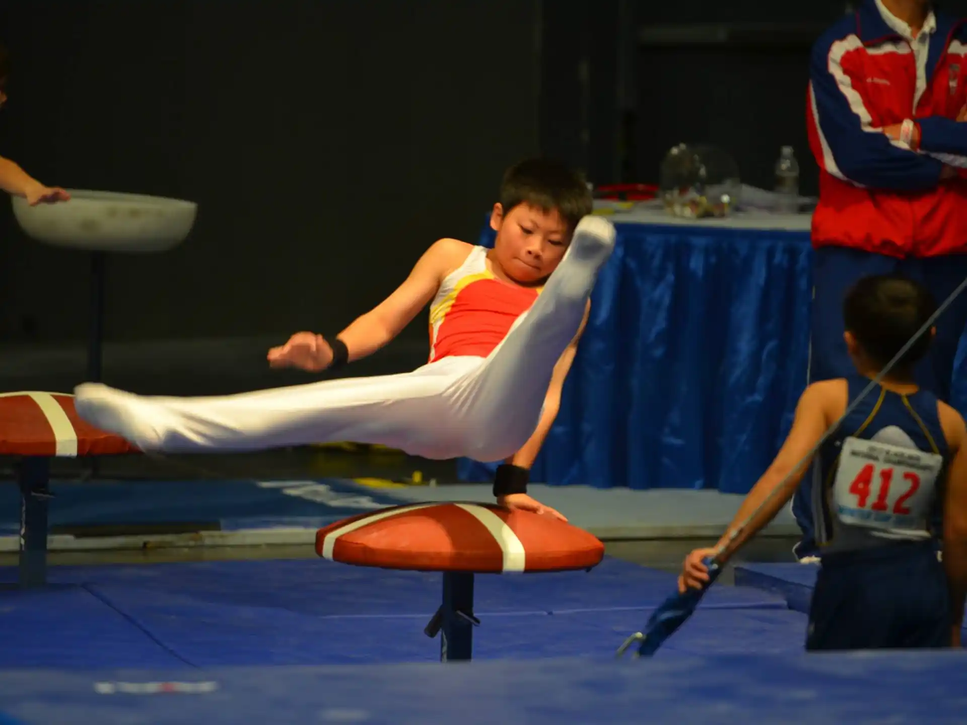 a person in a karate uniform kicking a white object in the air