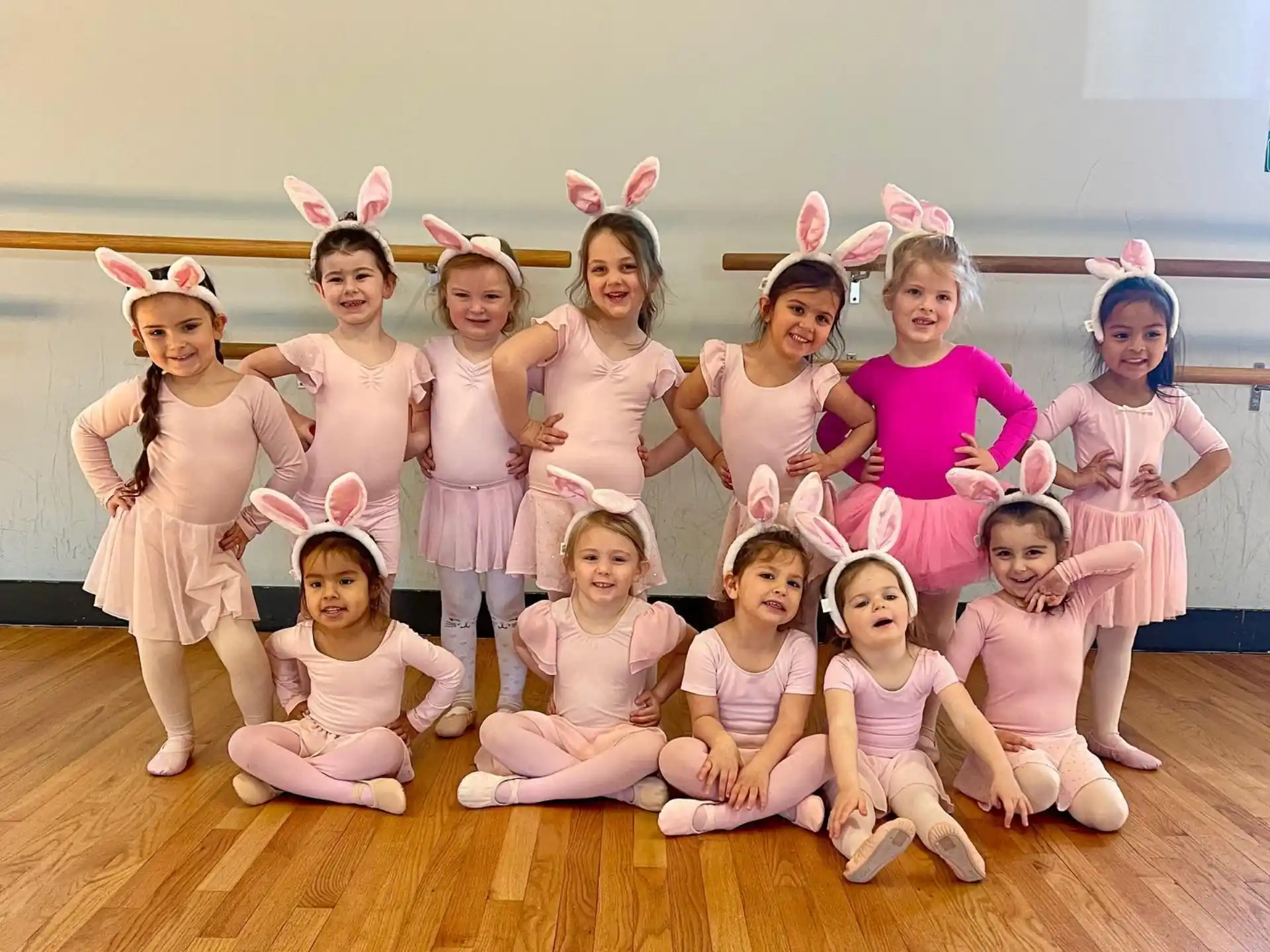 a group of girls in pink and white dresses