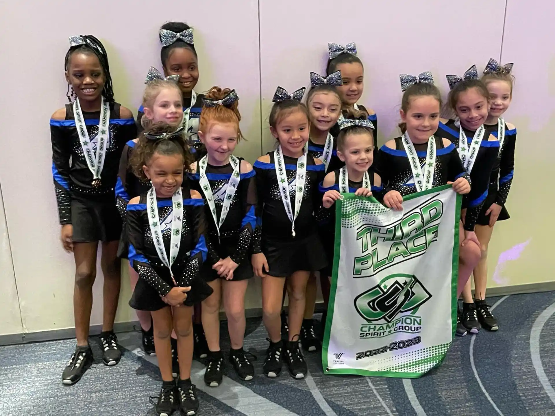 a group of girls wearing black and white uniforms and holding a sign