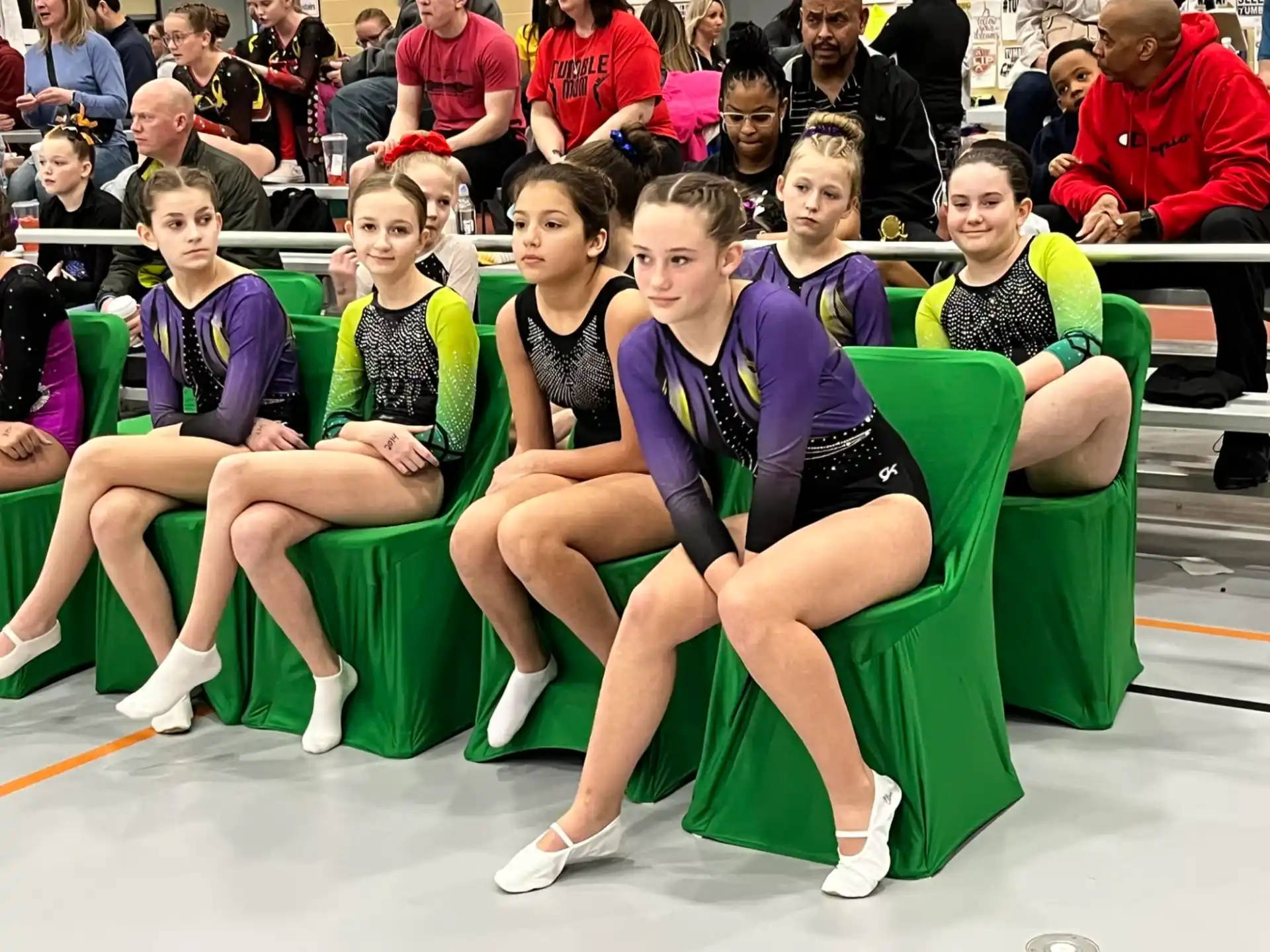 a group of people sitting in green chairs