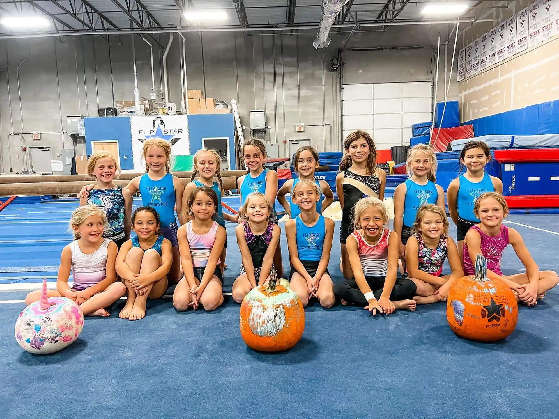 a group of children posing for a photo with pumpkins