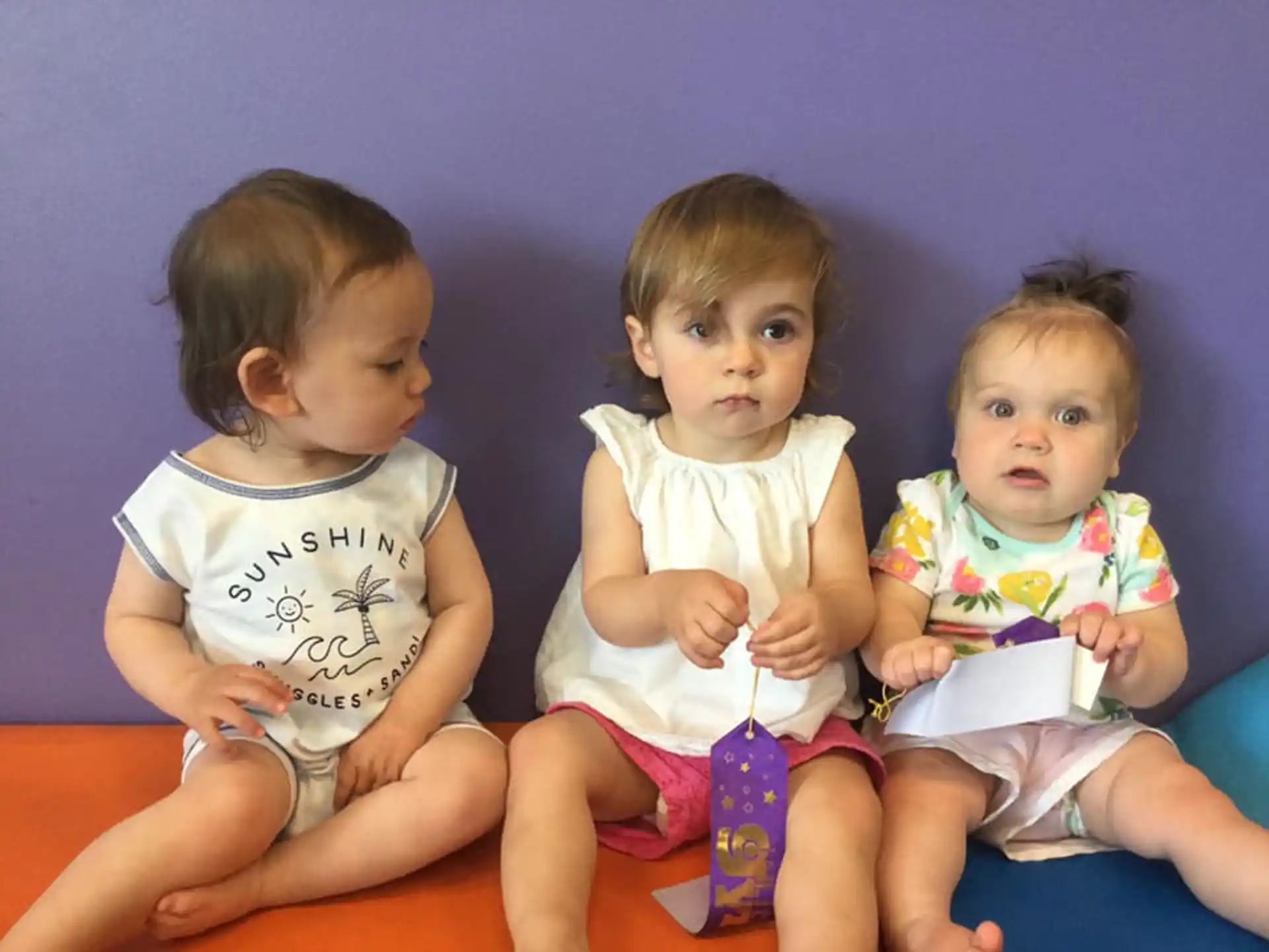 a group of babies sitting on a bed