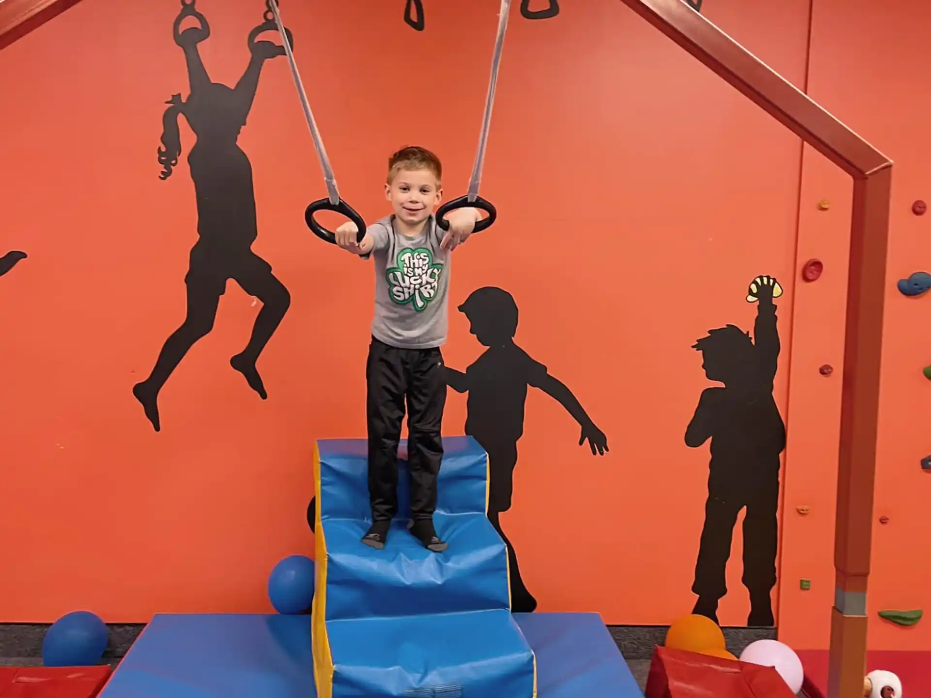 a boy standing on a swing set