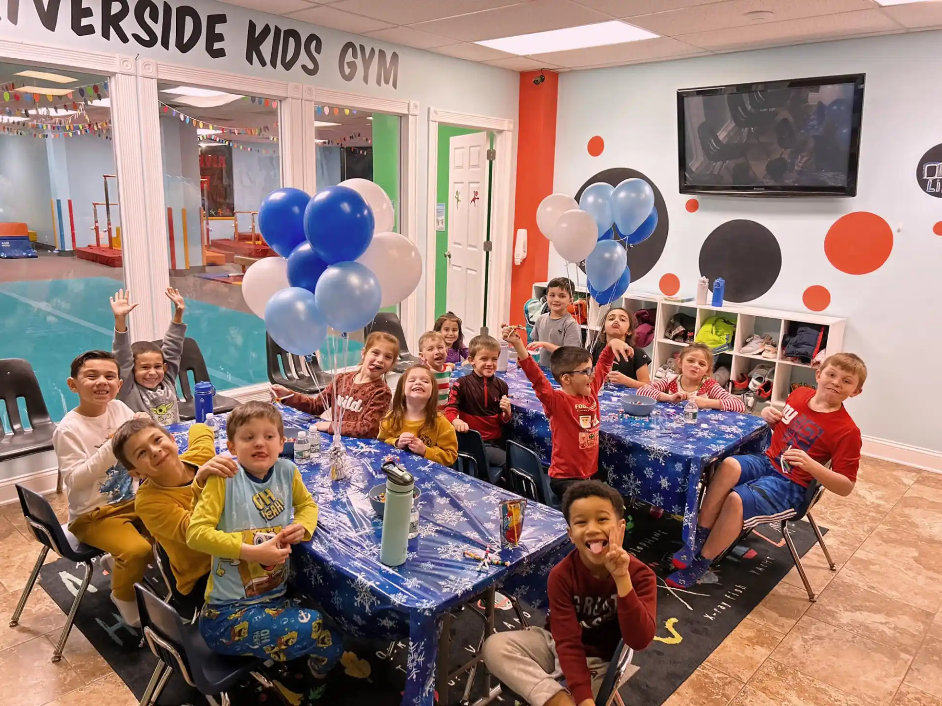 a group of people sitting at a table with balloons