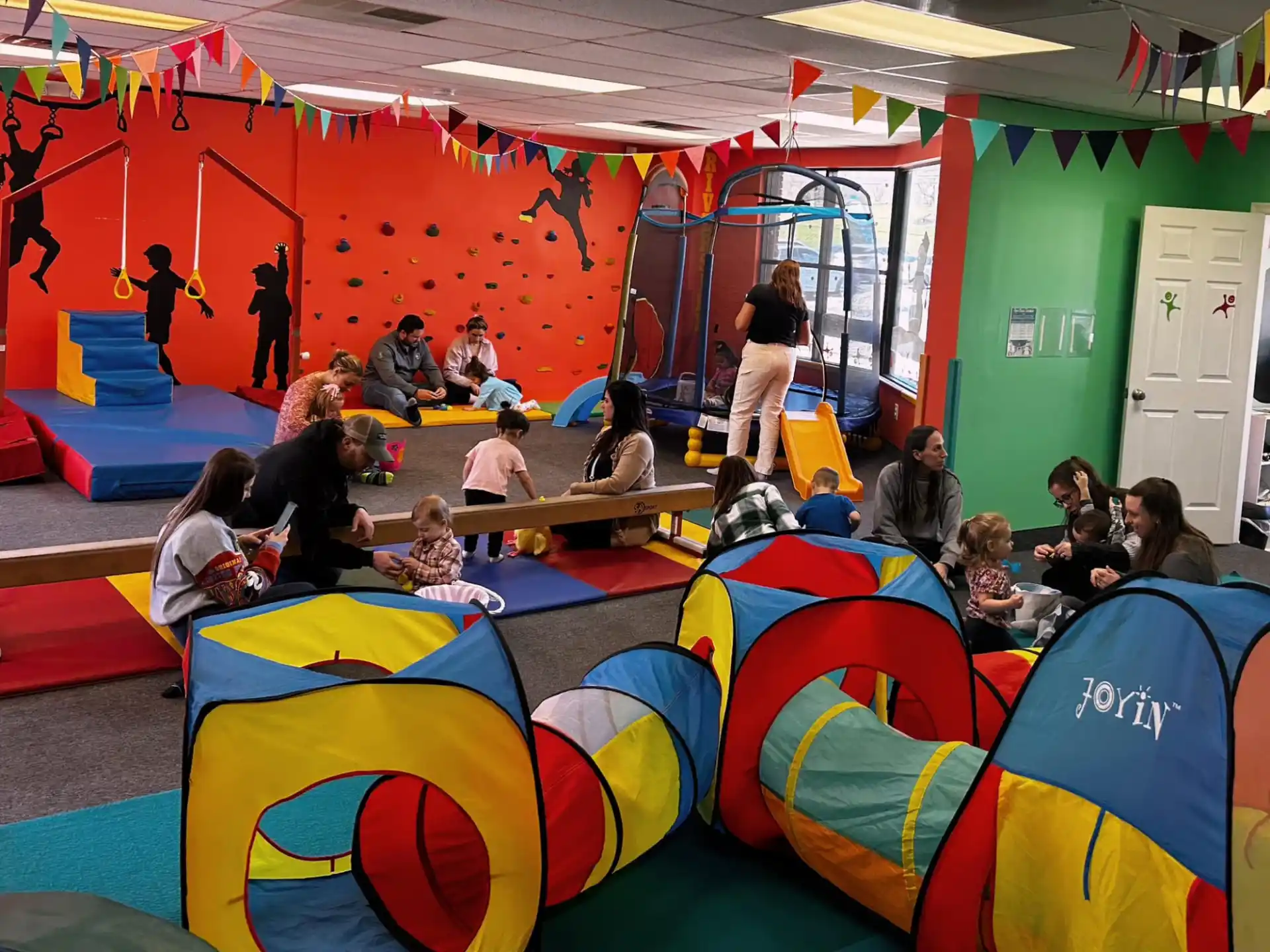 a group of people sitting in a room with colorful balls