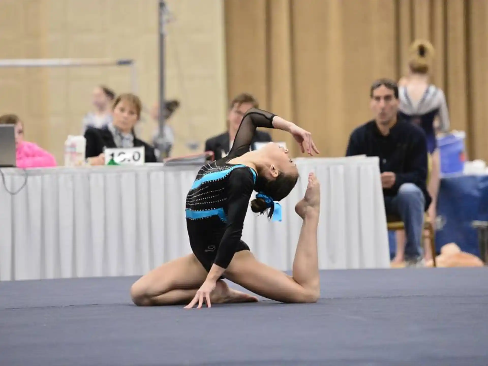 a person doing a handstand on a mat in front of a crowd