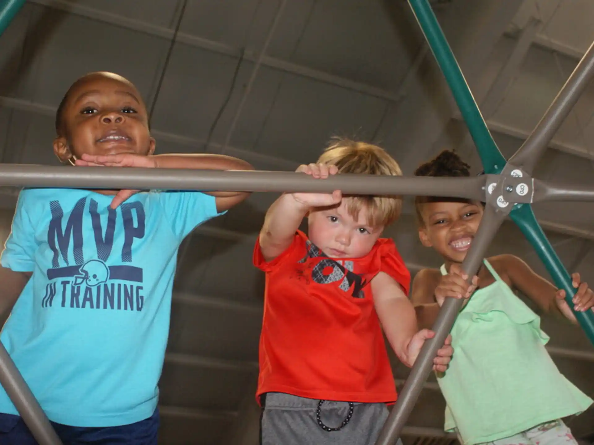 a group of kids holding onto a pole