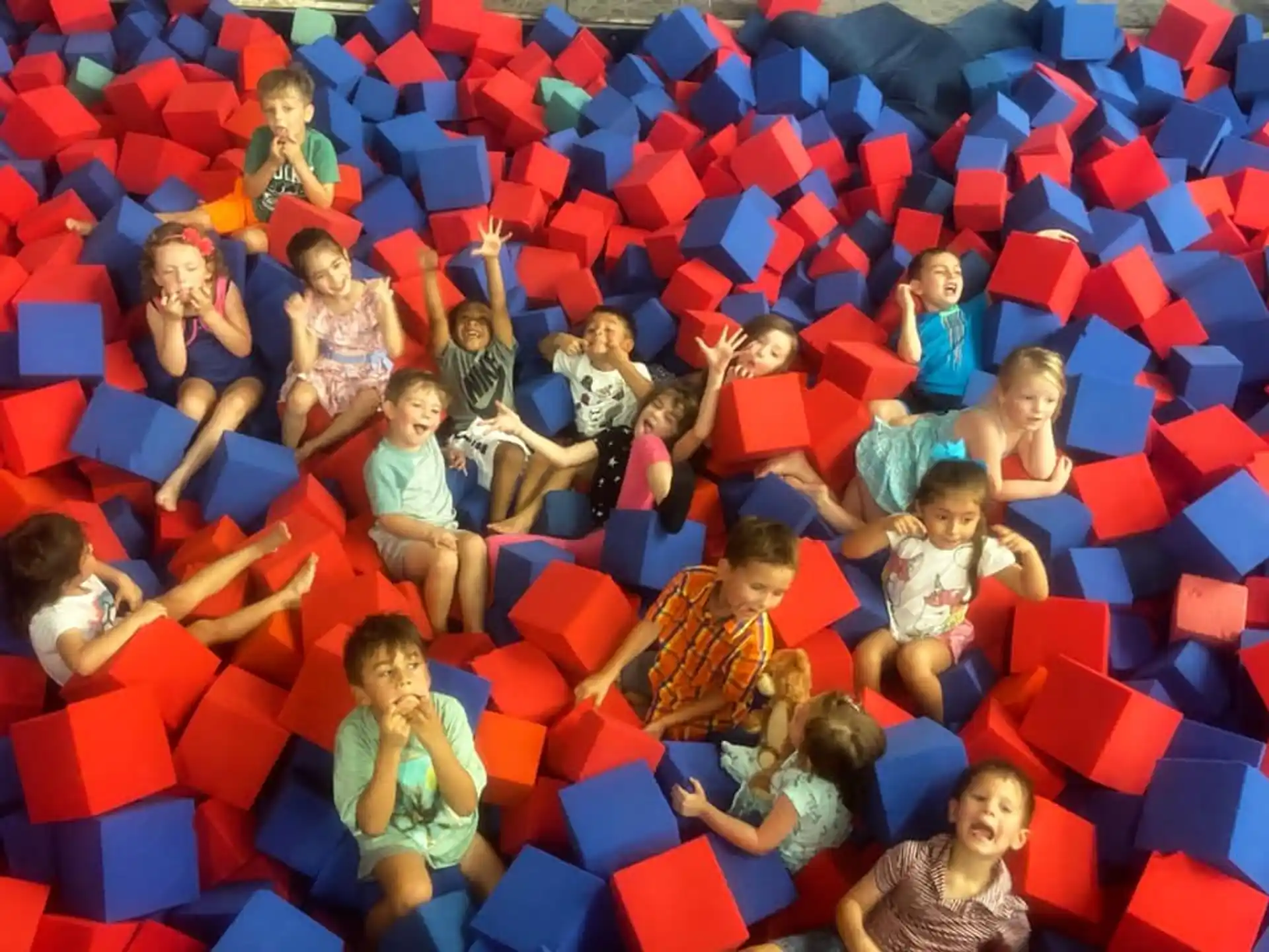 a group of children sitting on a red and yellow slide