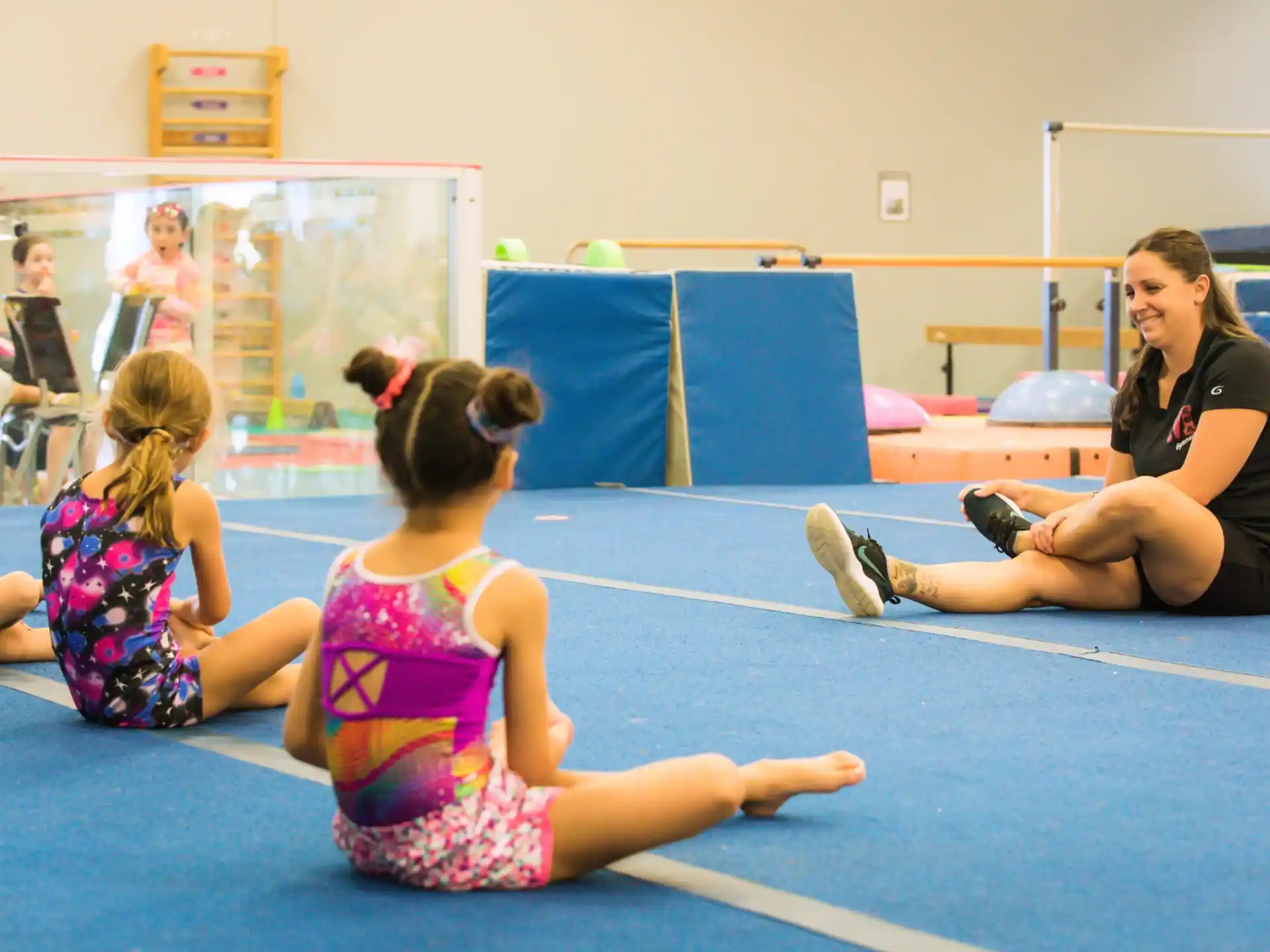 a person and two girls sitting on the floor