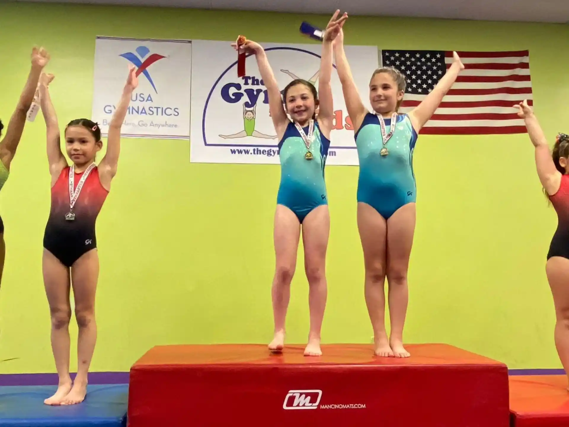 a group of women in leotards on a podium