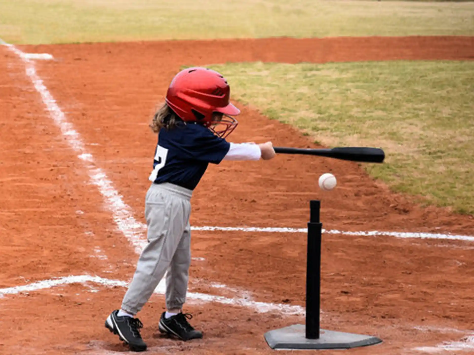 a little boy hitting a ball with a baseball bat