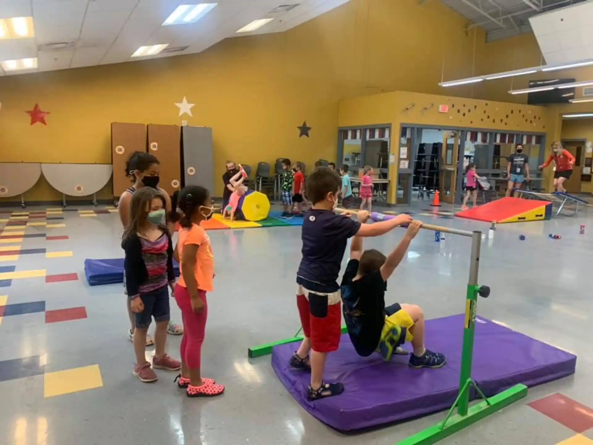 a group of children playing on a mat in a gym