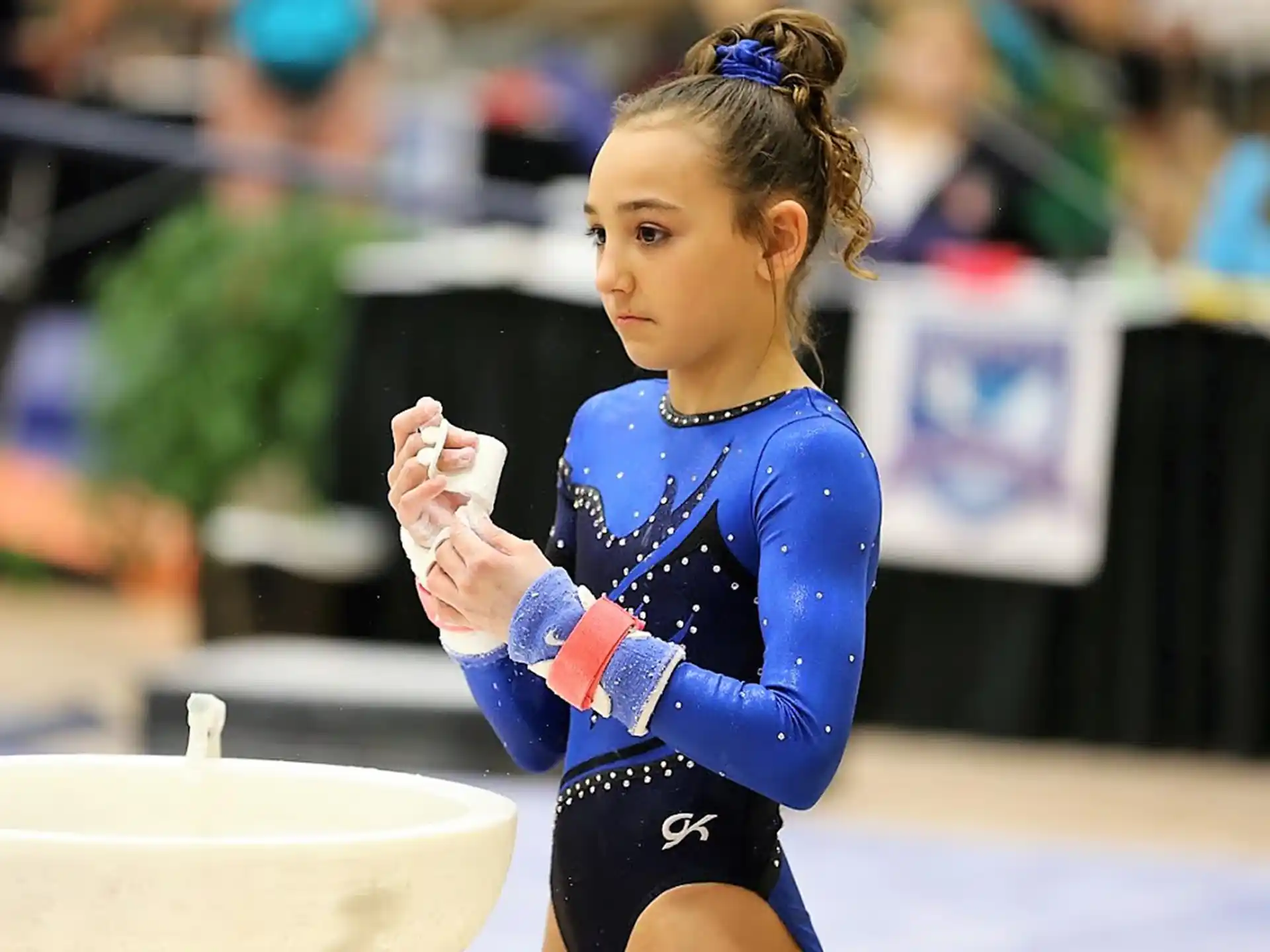 a girl wearing a blue leotard and gloves