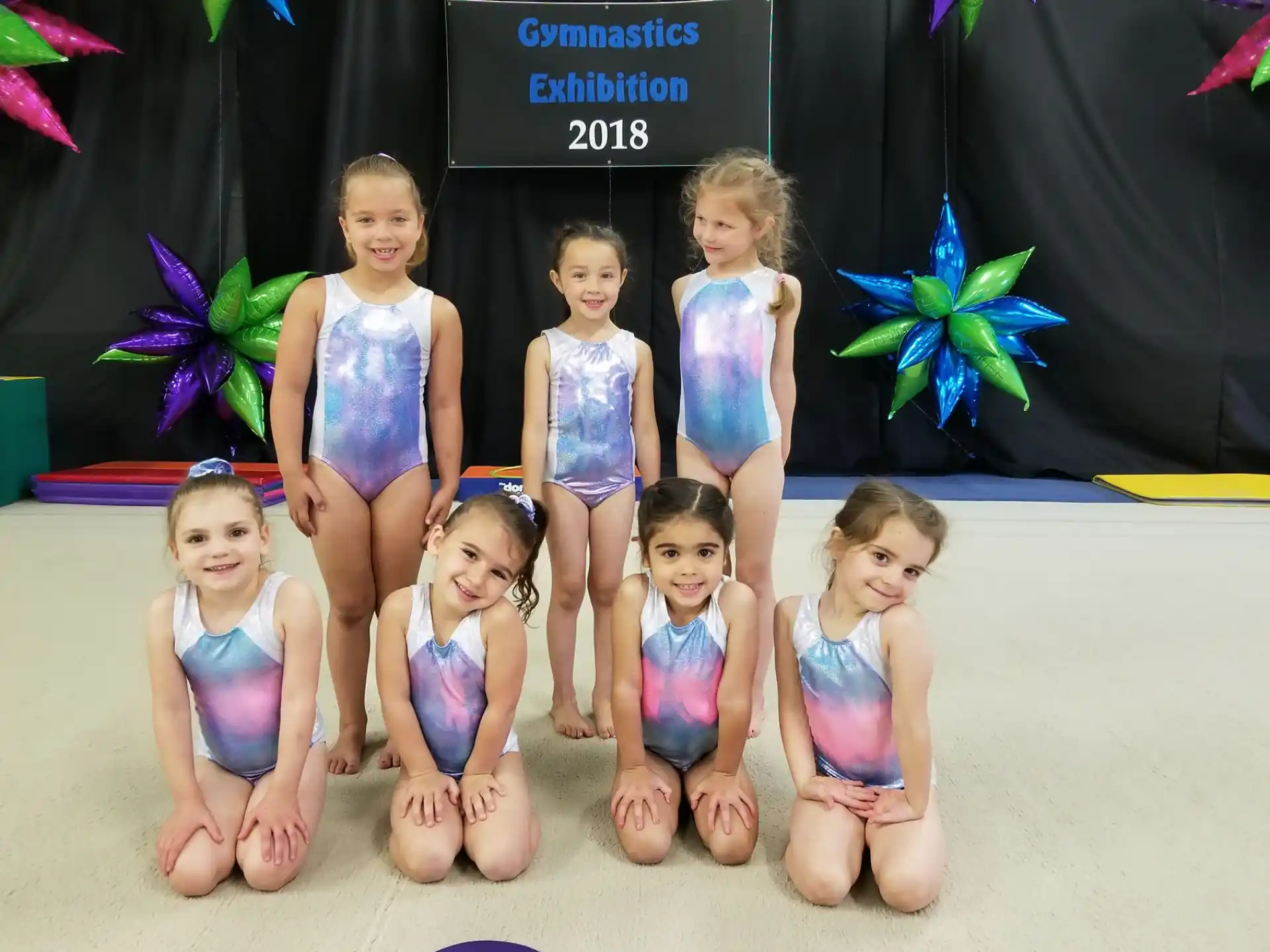 a group of girls in swimsuits posing for a photo
