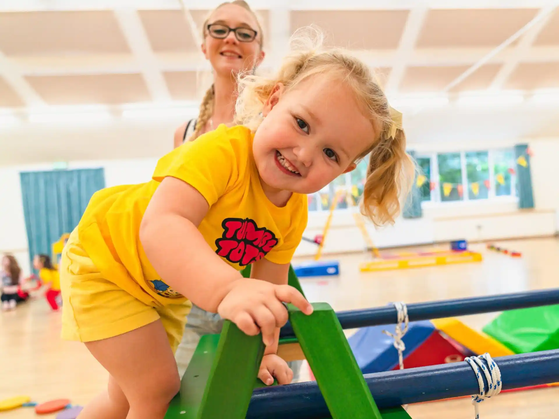 a girl smiling and playing on a toy train