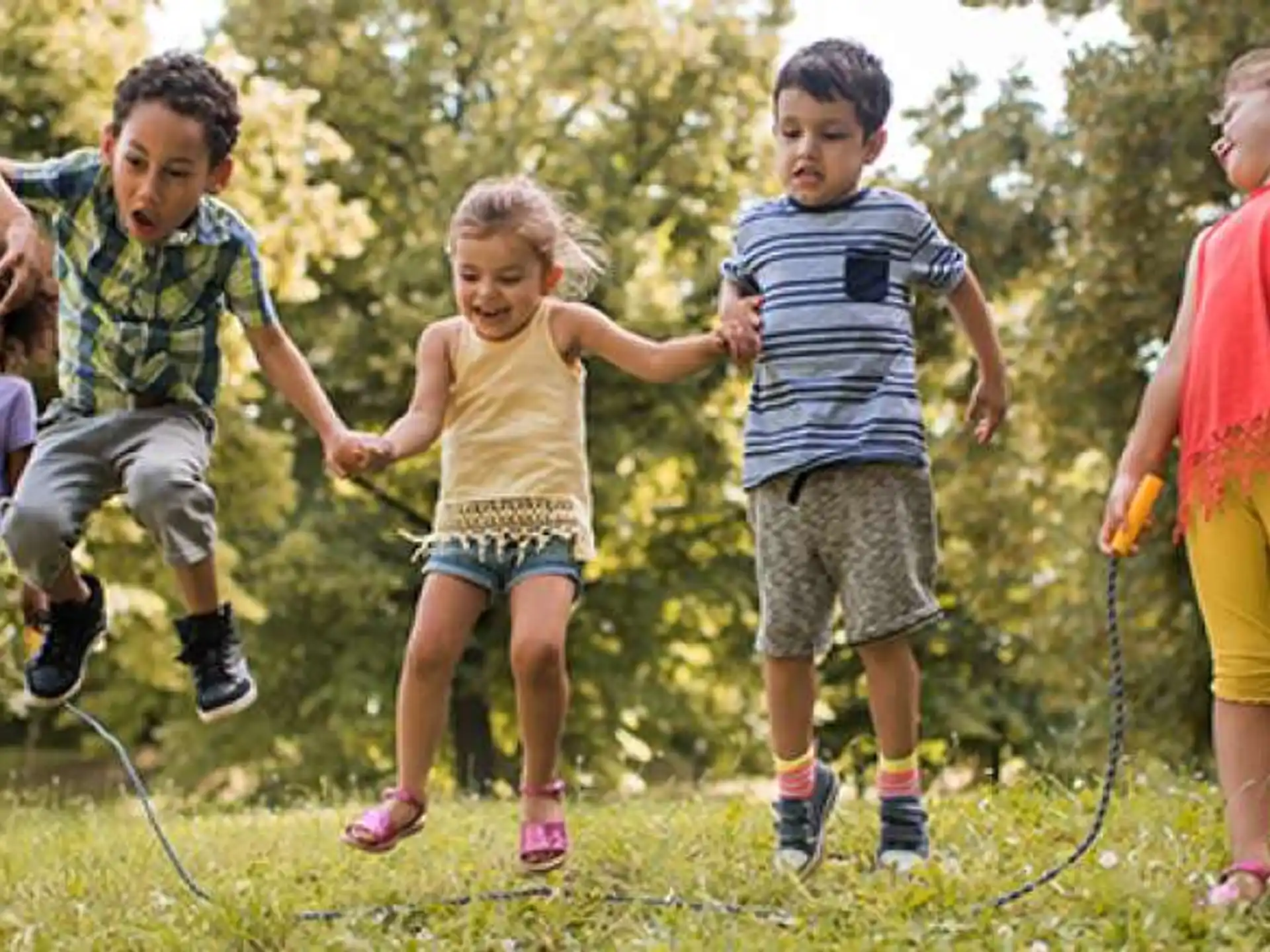 a group of children playing in a grassy area