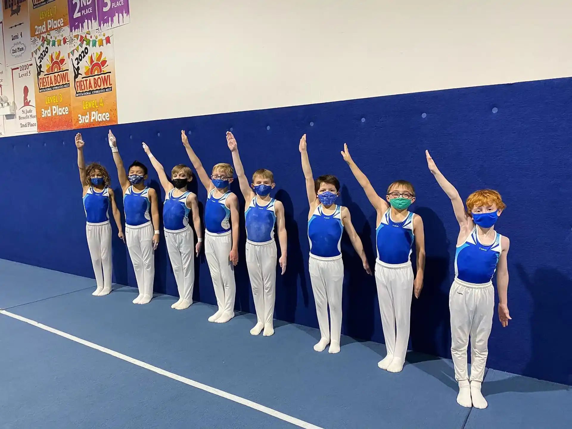a group of people wearing blue and white outfits standing on a track