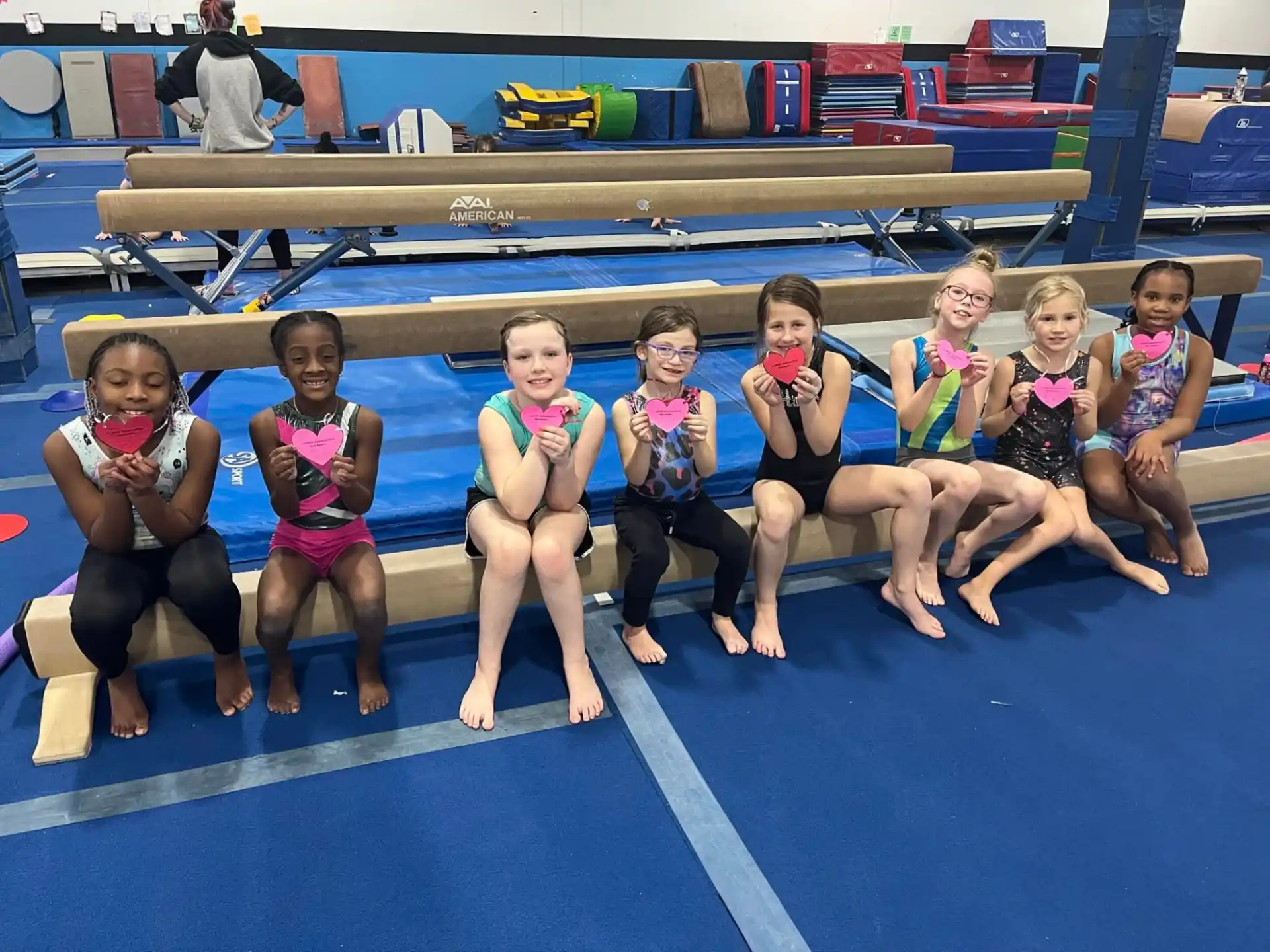 a group of girls sitting on a mat in a swimming pool