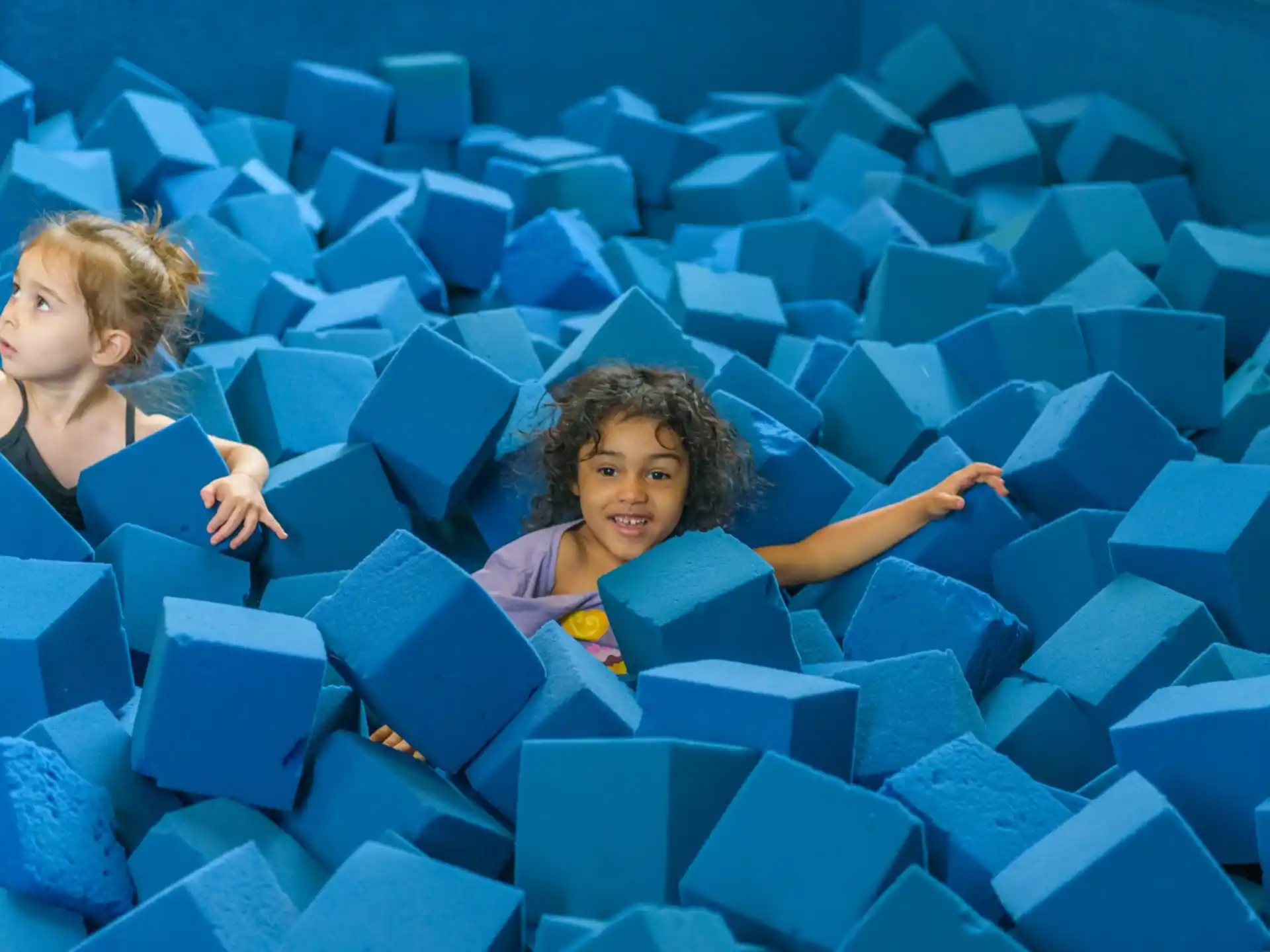 a couple of women in a large room with blue chairs