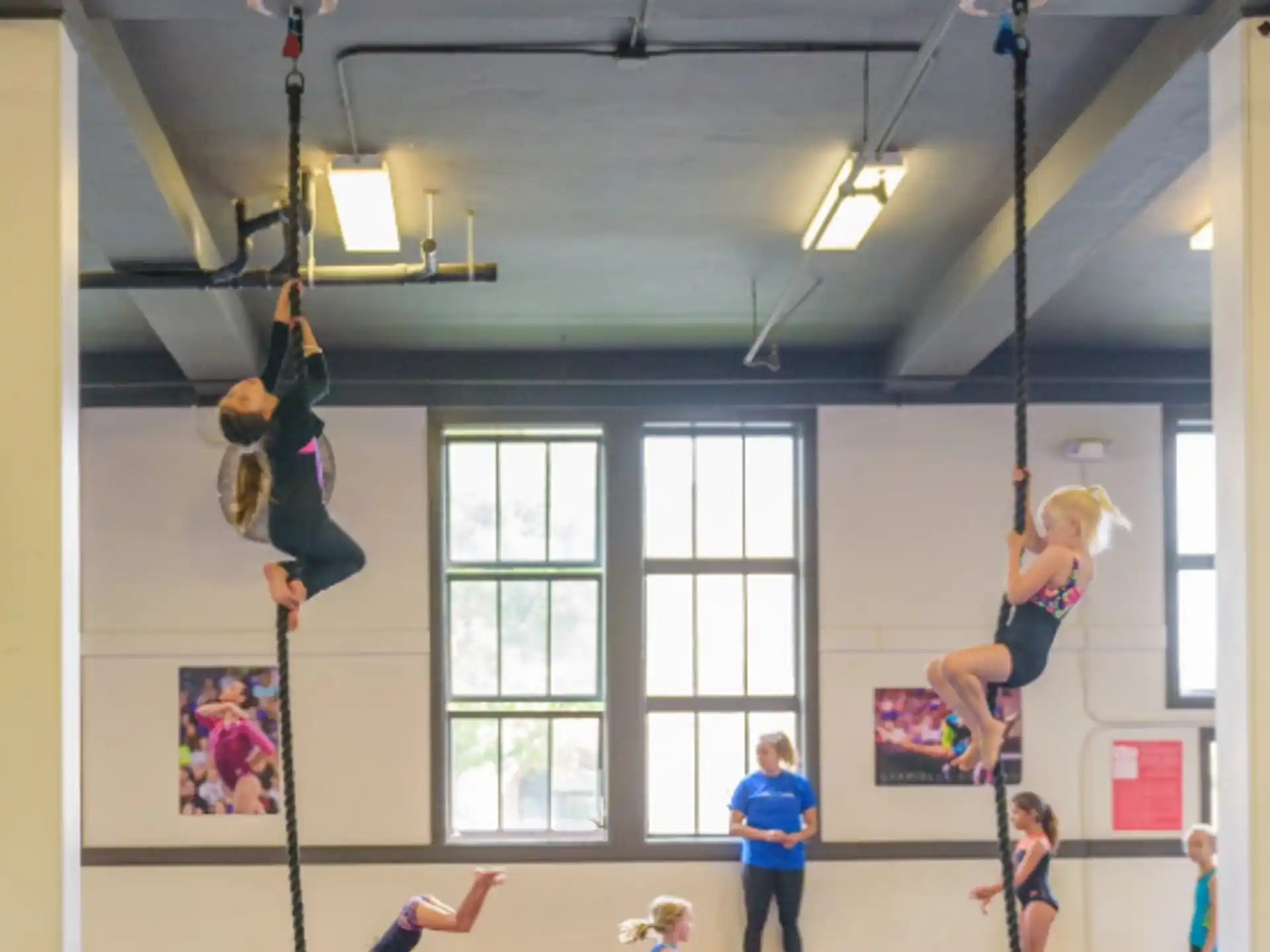a group of people from a rope in a room with windows