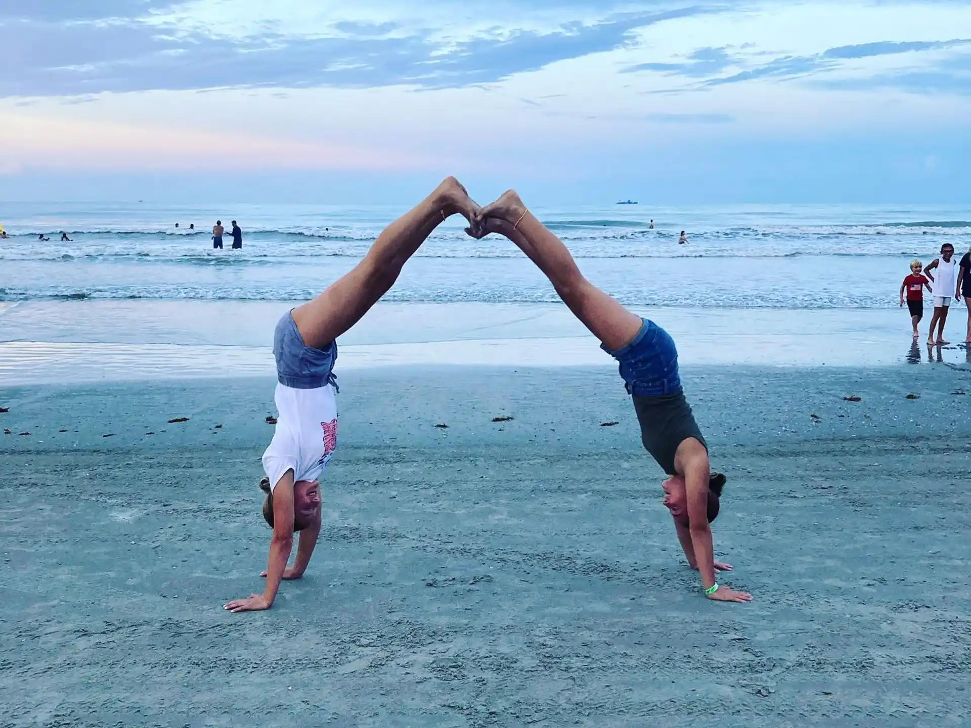 a man doing a handstand on a beach