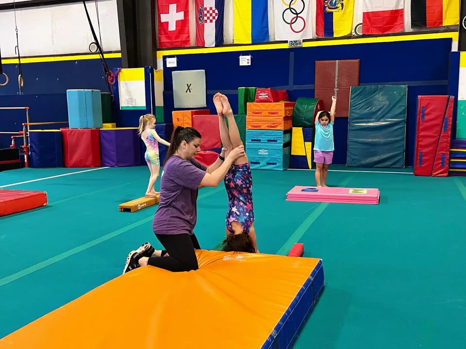 a group of kids playing on a mat in a gym