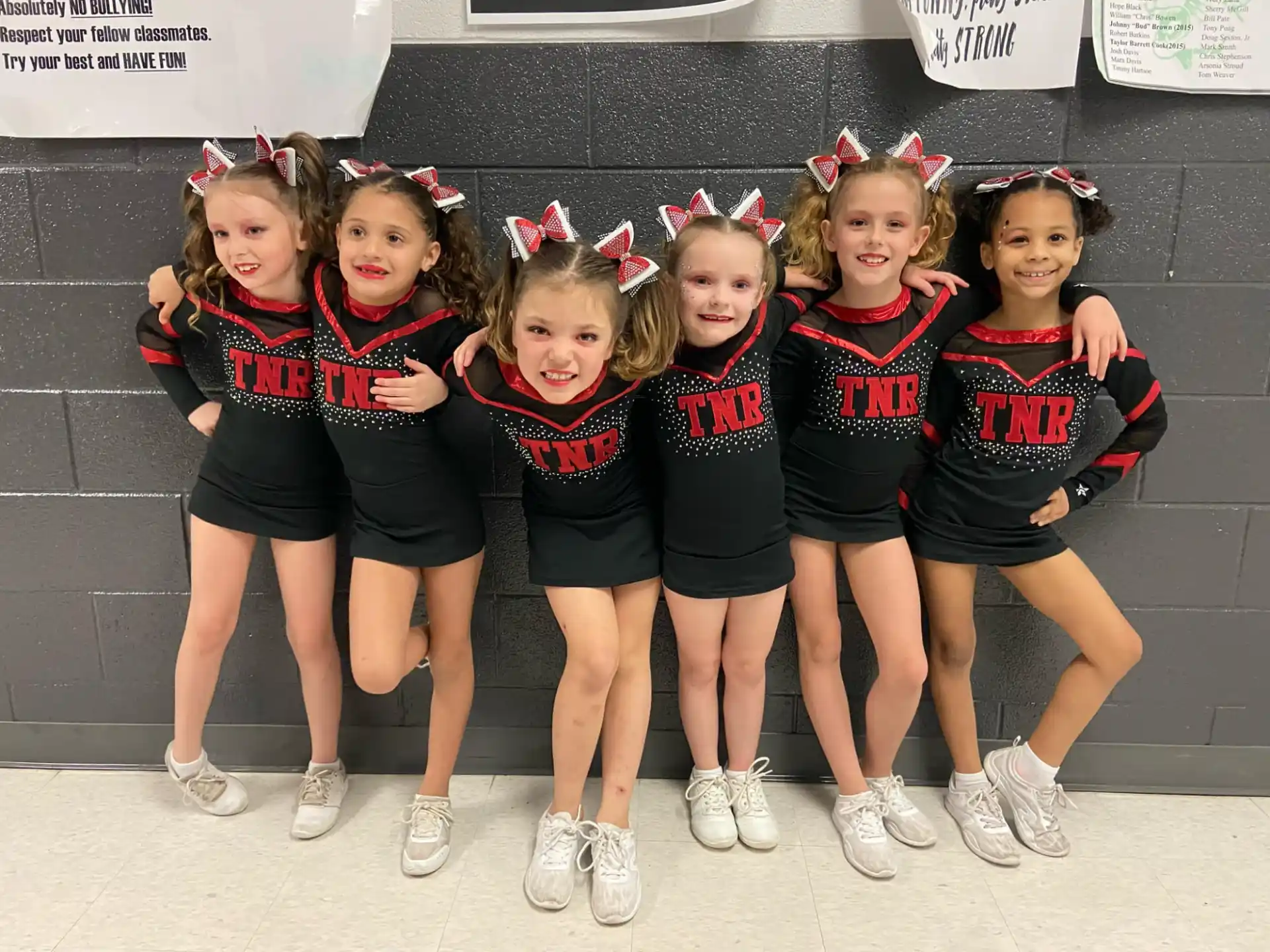 a group of girls in matching black and red uniforms