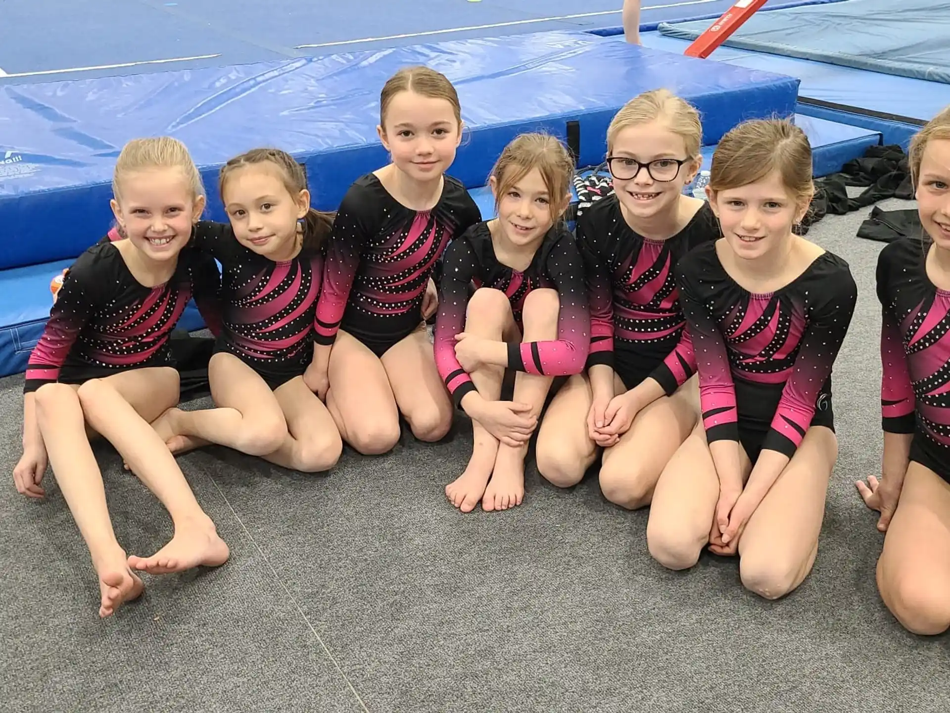 a group of children in swimsuits sitting on the ground