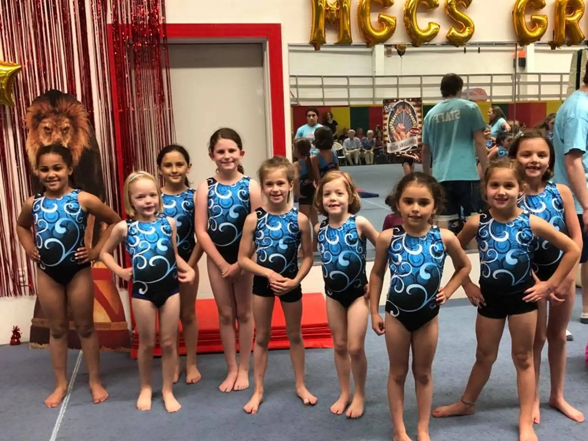 a group of girls in blue leotards posing for a photo