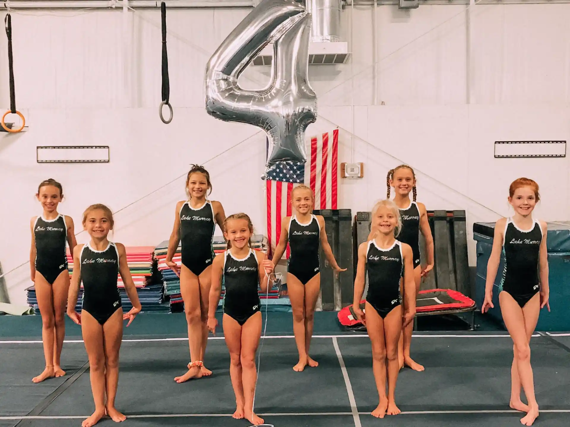 a group of women in black leotards on a track