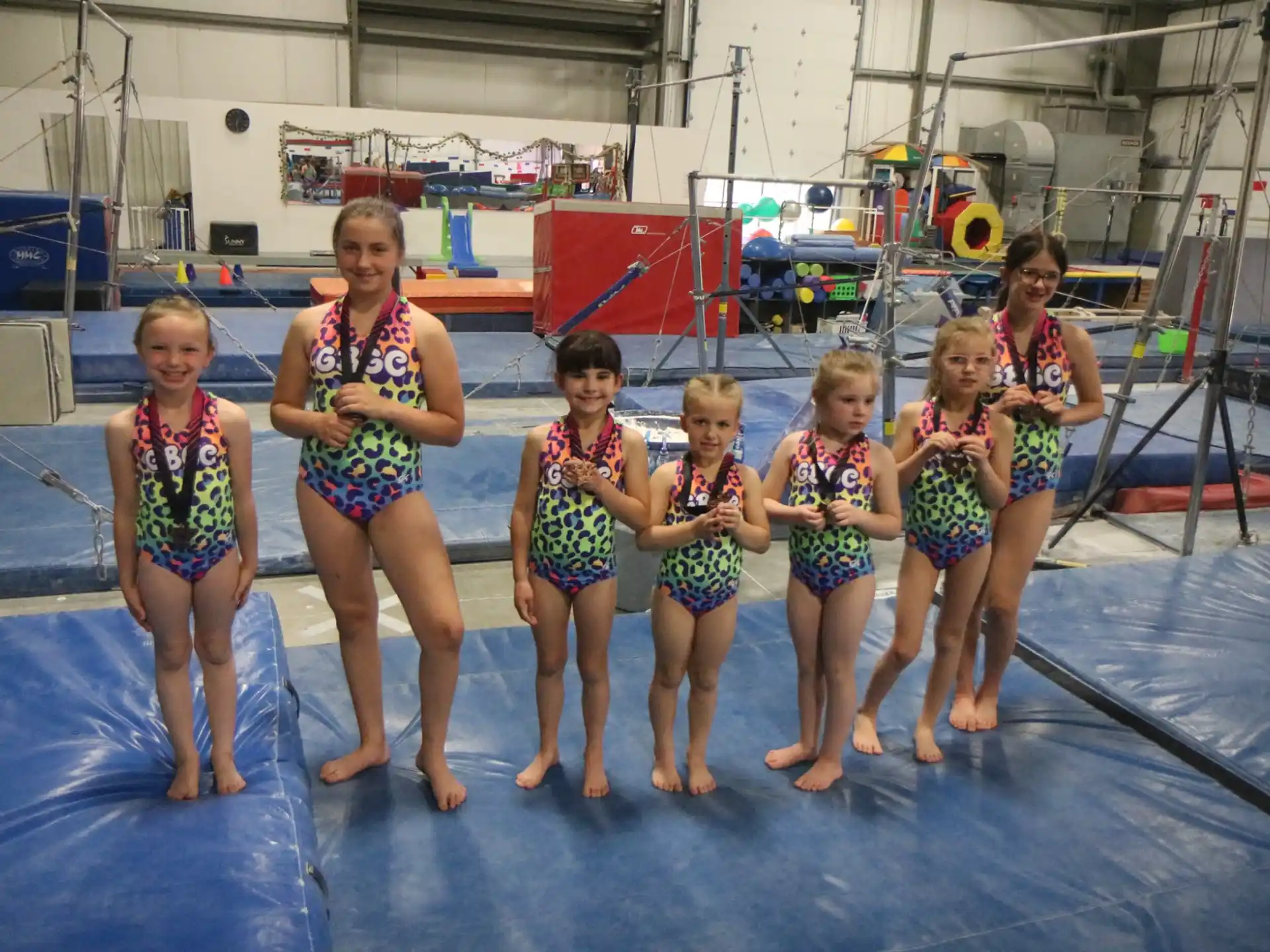a group of girls in swimsuits standing in a pool